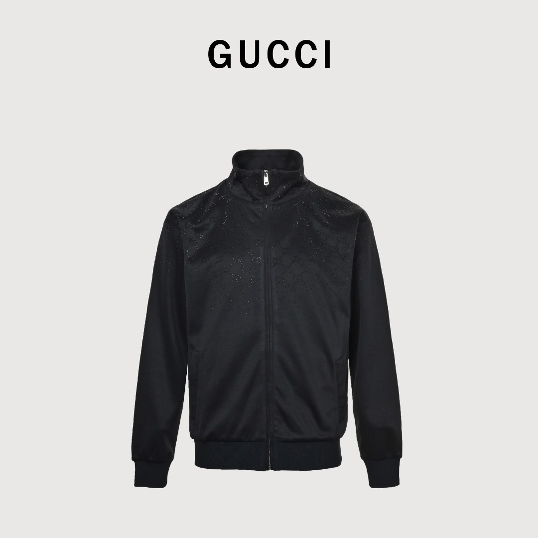 GUCCI古驰GUC 肩亮片GG饰仿水晶立领拉链外套 采用55%聚酯纤维与45%棉混纺的针织面料为主体,辅件则运用97%聚酯纤维搭配3%氨纶的弹性材质,口袋里布为100%棉,面料组合兼顾了挺括度与穿着舒适度,版型上采用oversized宽松剪裁,立领设计结合金属拉链门襟,形成利落的视觉线条,袖口与下摆的罗纹收边采用氨纶混纺弹性罗纹,增强了服装的贴合度与耐穿性,衣身通体点缀烫钻工艺装饰,以密钉式镶钻手法打造出低调的闪耀质感,侧缝嵌线口袋的嵌边车缝工艺规整,整体将高级成衣的材质运用、结构设计与装饰工艺融为一体