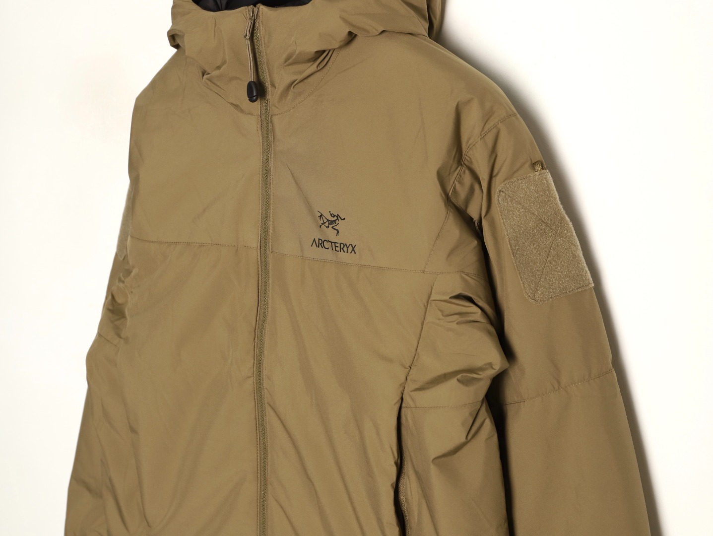 🔝Arc·teryx 始祖鸟男女款军鸟棉服 Leaf Cold  Gen 2 防风保暖连帽棉服
冬季 情侣款军版向导级防风软壳厚棉服!这款外层用了N40p WINDSTOPPER 2L面料，填充Coreloft 100克级保暖棉，填补了军鸟中等厚度棉服的空白。属于Cold  系列的有帽版本，全防风，很好的保暖，穿着轻巧舒适是其主要特点！一般作为外套使用，搭配其他中层和内衣使用。衣服面料为大名鼎鼎的windstopper面料,n40p 面料柔软度介于老款的Gossamera和Fusion的WS。所以既可用于外套，也可以搭配冲锋衣中间层使用. 特点： 1：外层WINDSTOPPER面料全防风，并有一定的防泼水，露，雪等能力，柔软度和耐用性均衡。填充材料Coreloft 有优秀的暖重比和热绝缘效率，易压缩性。拒水性很好。 2：内部腰部收紧拉链竖直设计最大效果防止和战术腰带发生钩挂和磨损。 3：肩部和手肘立体剪裁，具有优秀的运动性，不影响各种战术动作。 4：内部有一个带拉链的胸袋，外部有两个带拉链的插手袋，里面有开口可保证通讯线缆通过。左右双臂都有带拉链的臂袋，里面有挂环，可以利用臂袋存放物品。
顶级配置1:1面料 做工，棉服！低调奢华，保暖性不输羽绒！
黑色   狼灰色  鳄鱼色
R1 SIZE:S-XXL