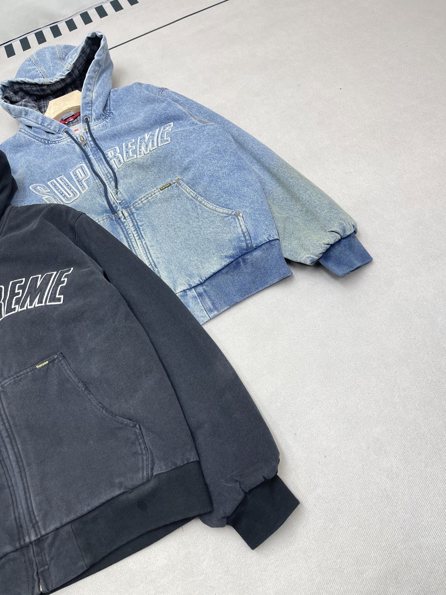 💰460🔥Supreme FW25 WEEK1 Reflective Arc Hooded Work Jacket 反光徽标字母拉链开合连帽工装夹克棉服外套 男女同款
全单宁牛仔面料 绗缝棉法兰绒里衬。正面下方有大口袋，内部胸袋。针织罗纹袖口和下摆。正面有3M®反光与字母徽标贴花。内里格子布千米起订  上身很好看的秋冬新款
颜色：水洗蓝 水洗黑色
尺码：S M L XL
         肩宽    衣长  胸围    袖长
S        58       68     136    66
M       60       70     140    67
L        61       72      144    68
XL      62       74      148    69