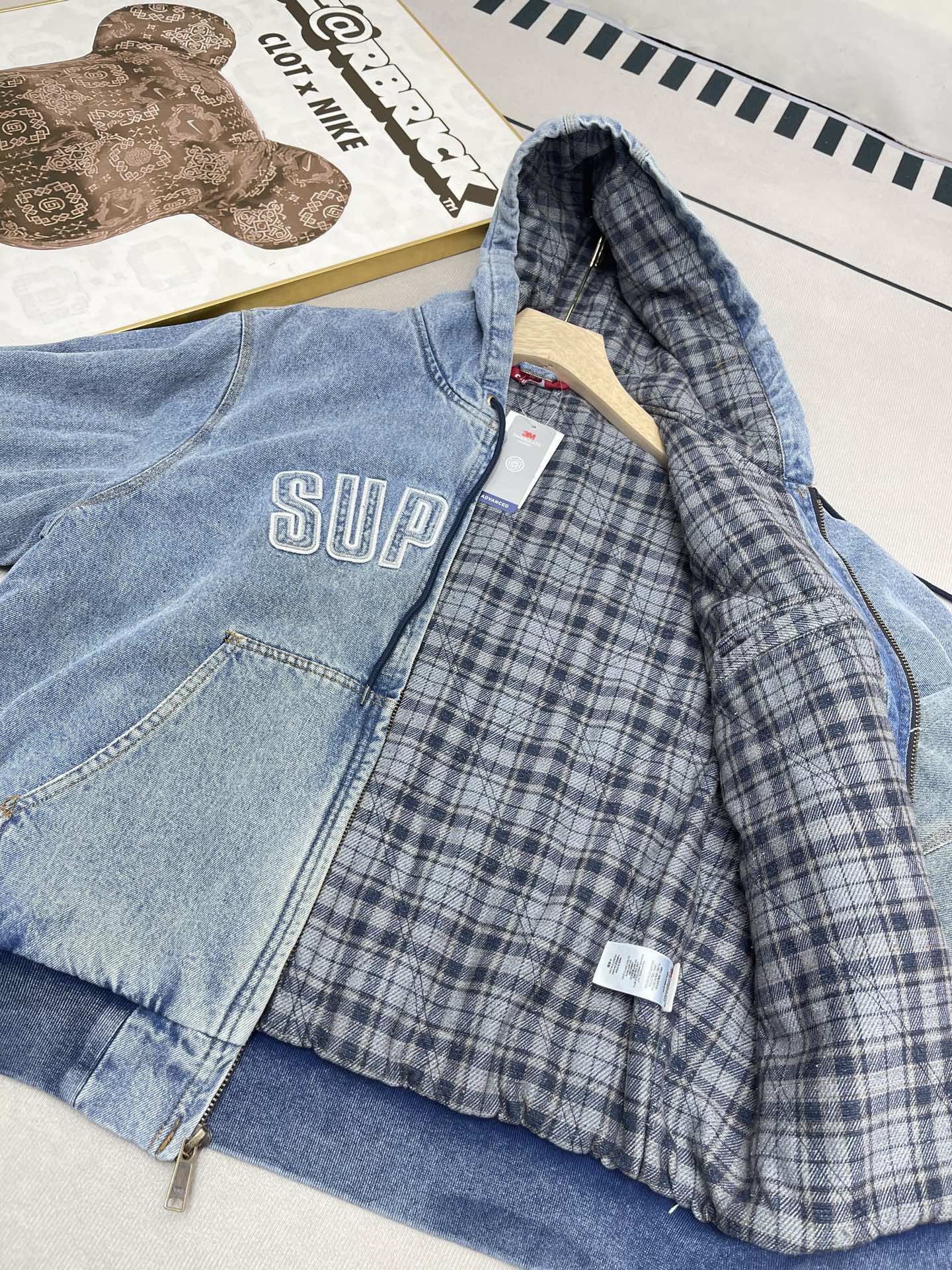 💰460🔥Supreme FW25 WEEK1 Reflective Arc Hooded Work Jacket 反光徽标字母拉链开合连帽工装夹克棉服外套 男女同款
全单宁牛仔面料 绗缝棉法兰绒里衬。正面下方有大口袋，内部胸袋。针织罗纹袖口和下摆。正面有3M®反光与字母徽标贴花。内里格子布千米起订  上身很好看的秋冬新款
颜色：水洗蓝 水洗黑色
尺码：S M L XL
         肩宽    衣长  胸围    袖长
S        58       68     136    66
M       60       70     140    67
L        61       72      144    68
XL      62       74      148    69