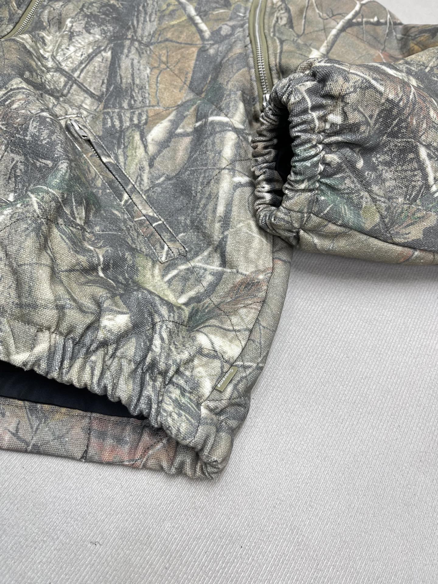 💰380🔥 Supreme FW25 WEEK1 Zip-Off Sleeve Quilted Bomber Jacket 可拆卸拉链袖子飞行夹克马甲二合棉服外套 男女同款
绗缝棉质帆布面料，棉混纺衬里。全拉链门襟，正面下方有双贴边拉链插手口袋，内部胸袋。袖子可拆卸，针织罗纹领口，弹性袖口和下摆。后颈有编织徽标标签。
颜色：黑色 蓝色 树枝迷彩
尺码：S M L XL
          衣长      胸围      肩宽     袖长
S         63         131        53.8       63
M        65         135       55          64
L          67         139       56.2      65
XL       69         143       57.4      66