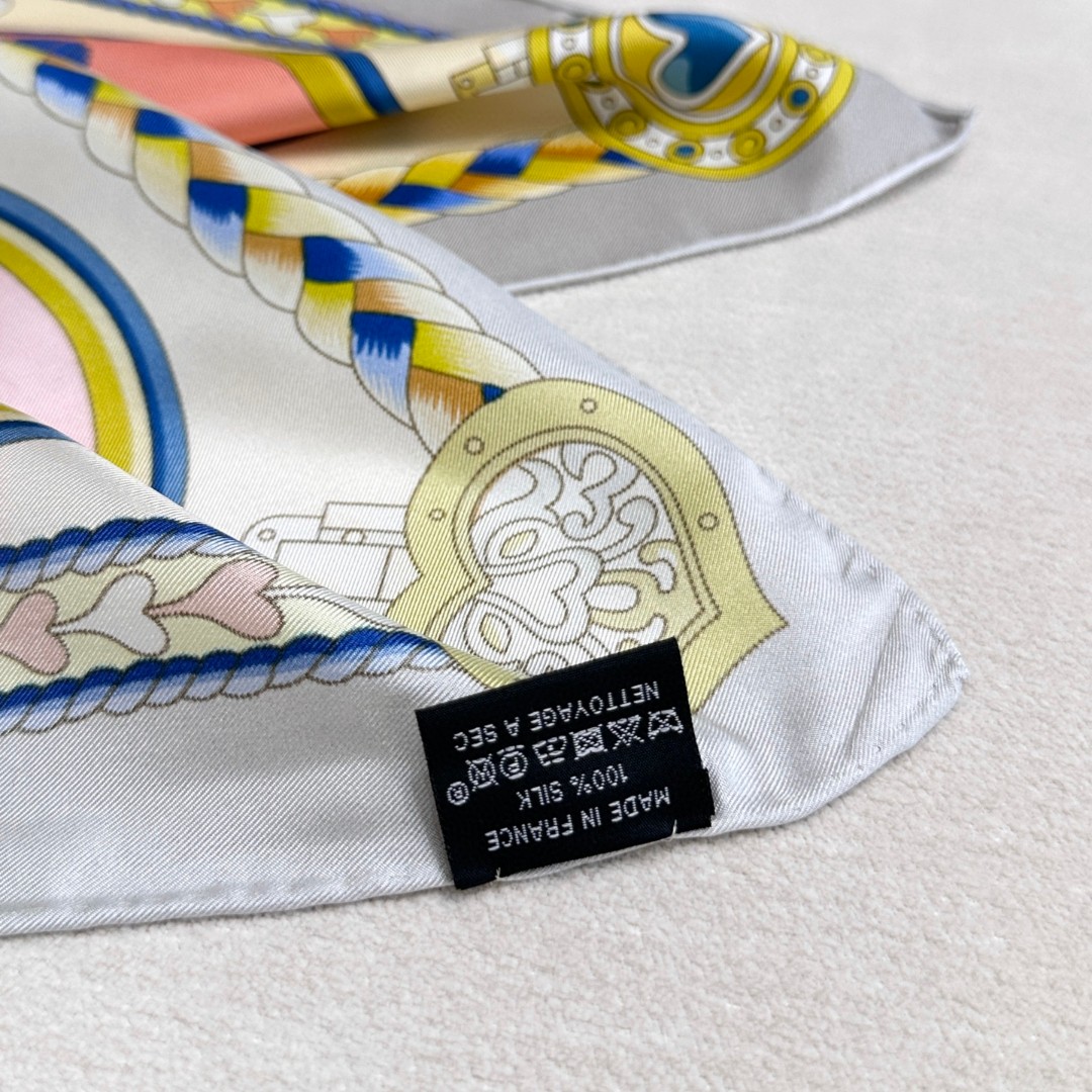 。甜蜜的鞍具”90方巾
手工卷边斜纹真丝方巾（100%桑蚕丝）。
这款爱马仕的经典单品展现强大而迷人的女