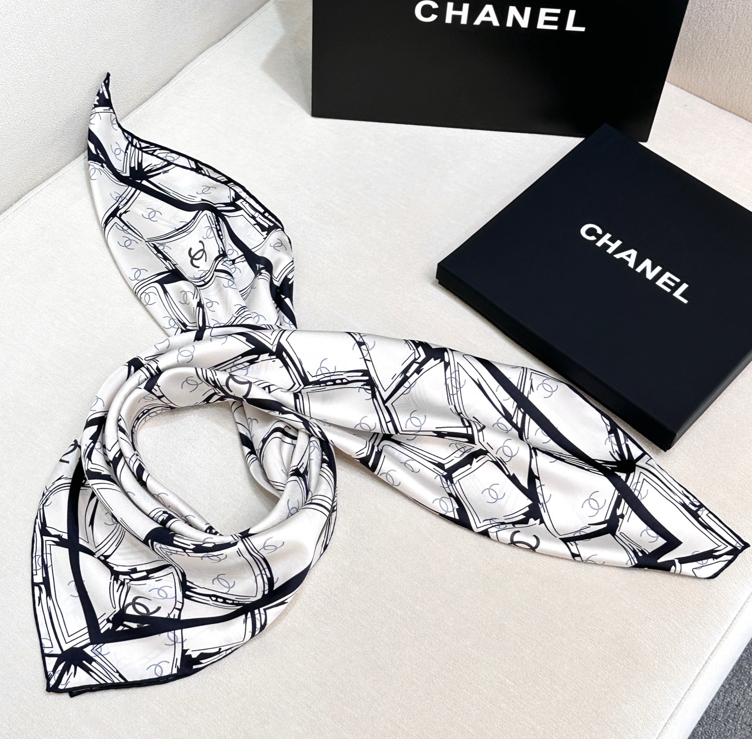  
香奈儿（CHANEL）新款丝巾。丝巾上以黑白线条交织的几何图案形式呈现,展现出一种现代感与艺术感，其