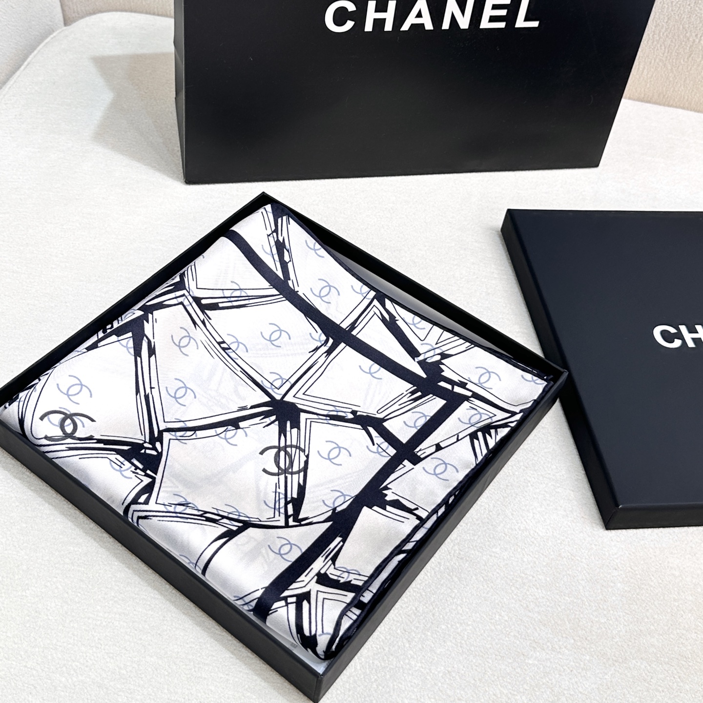  
香奈儿（CHANEL）新款丝巾。丝巾上以黑白线条交织的几何图案形式呈现,展现出一种现代感与艺术感，其