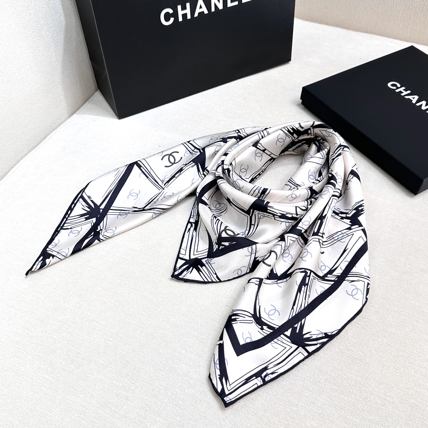  
香奈儿（CHANEL）新款丝巾。丝巾上以黑白线条交织的几何图案形式呈现,展现出一种现代感与艺术感，其