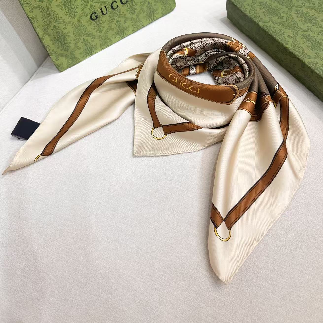 gucci～印花桑蚕丝斜纹方巾2026早春系列植根品牌本源，匠心呈现这款缀饰通体Gucci饰带和马衔扣印