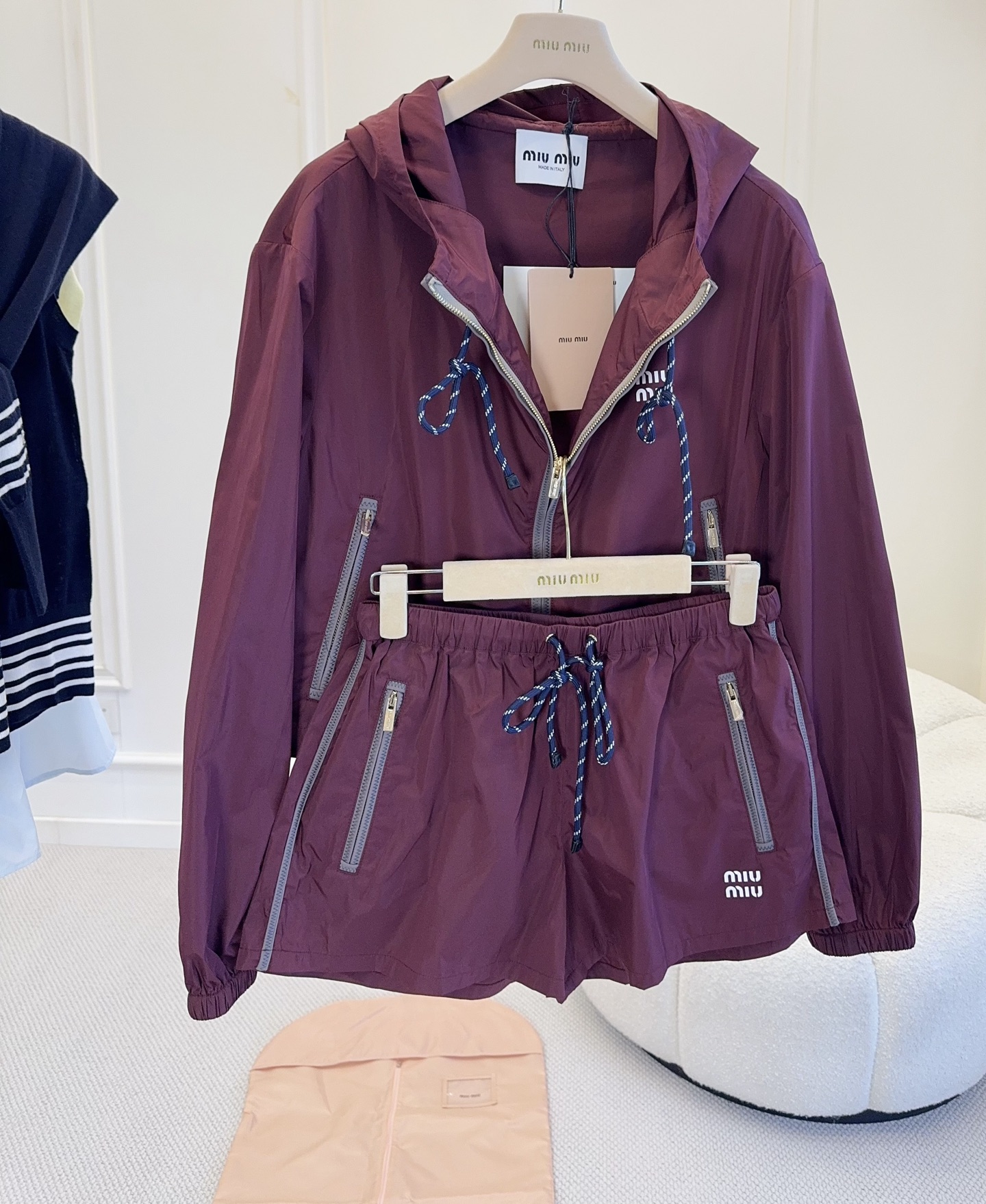 NO:799709,Miu Miu2026 new burgundy hooded jacket shorts, nylon material, light and windproof, drawstring + loose tailoring, retro and practical!  The burgundy color is low-key and luxurious. It is very suitable for spring and autumn. It looks great when worn alone or layered. The hooded design is full of casualness. Paired with a pleated skirt and Mary Jane shoes, you can easily get a college style or a sweet and cool style. The combination of one set will make your legs look longer!  ,,miumiu,mary jane,skirts,shorts,jackets & coats,hats,19860909Miu Miu2026新款酒红色连帽外套短裤,尼龙材质轻薄防风,抽绳+宽松剪裁,复古又实用！酒红色低调奢华,春秋季节穿搭超合适,单穿或叠搭都很出彩.连帽设计休闲感满满,搭配百褶裙、玛丽珍鞋,轻松get学院风or甜酷风,一套搭配超级显腿长！,,miumiu,mary jane,skirts,shorts,jackets & coats,hats,,Women's clothing