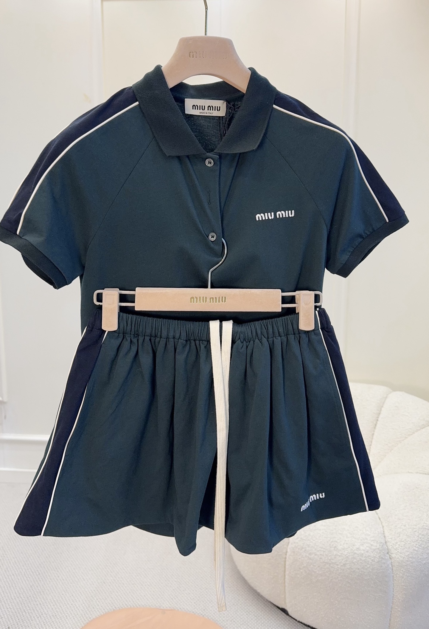 NO:800203,Polo shirt + skirt Miu Miu 2026 new dark green Polo shirt + skirt, a mix of preppy style and sporty feel, sweet, cool and age-reducing!  Polo shirt with striped splicing + chest logo, full details of the drawstring design of the skirt, light and breathable, super comfortable to wear in spring and summer. The dark green color shows whiteness and does not pick on the skin tone, and can be easily used for daily outings, sports, and dates ~ Pair it with a white bag or baseball cap, and it will instantly make you feel fresh and fashionable!  ,,miumiu,skirts,hats,19860909Polo衫+短裙Miu Miu2026新款墨绿Polo衫+短裙,学院风混搭运动感,甜酷又减龄！Polo衫条纹拼接+胸口Logo,细节满分短裙抽绳设计,轻薄透气,春夏穿超舒服.墨绿色显白不挑肤色,日常出街、运动、约会都能轻松驾驭～搭配白色小包或棒球帽,清爽时髦感直接拉满！,,miumiu,skirts,hats,,Women's clothing