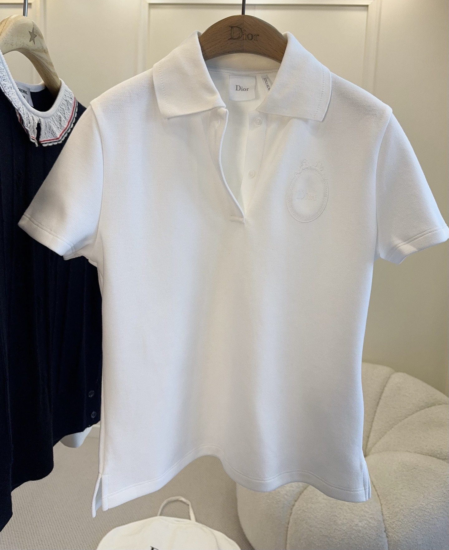 NO:801210,Dior2026 new white Polo shirt, pure cotton piqué, soft and breathable, super comfortable to wear in summer!  Classic lapel + three-button design, low-key embroidered logo on the chest, simple and high-end. Slit details at the hem, very design. It can be easily worn whether commuting, casual or college style. It goes well with skirts or overalls. It is a must-have and versatile item in the wardrobe!  ,,dior,skirts,19860909Dior2026新款白色Polo衫,纯棉珠地棉,柔软透气,夏天穿超舒服！经典翻领+三粒扣设计,胸前低调刺绣Logo,简约又高级.下摆开叉细节,很有设计感.无论通勤、休闲还是学院风都能轻松驾驭,搭配半裙或工装裤都很出彩,是衣橱必备百搭单品！,,dior,skirts,,Women's clothing