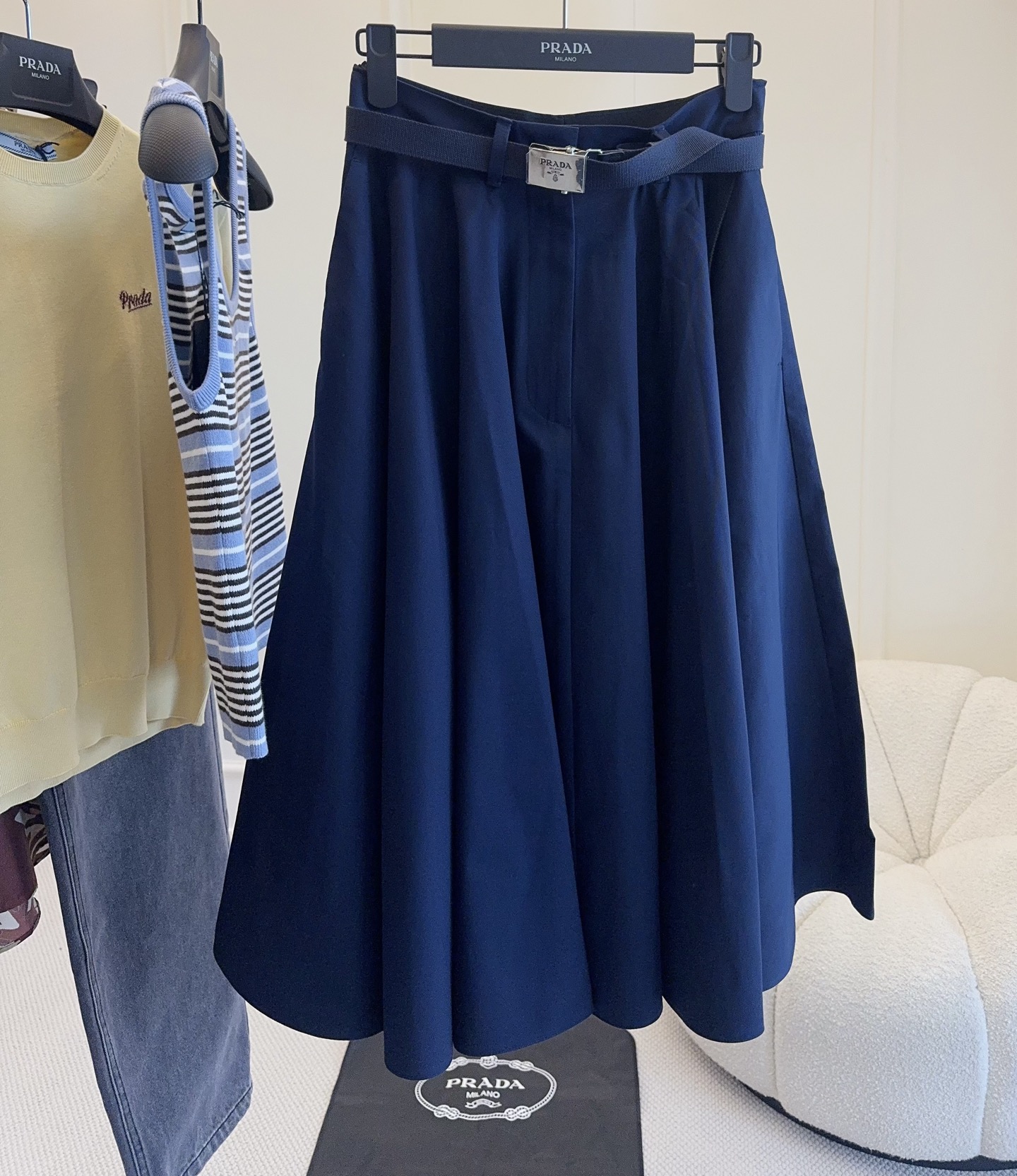 NO:802367,Prada's 2026 new navy blue high-waisted skirt is made of high-quality twill cotton fabric, with excellent drape and texture. A-line umbrella skirt design + belt of the same color, modify the waistline, elongate the leg proportions, look slim and elegant. The skirt length is moderate, and can be easily controlled for commuting, daily life and formal occasions. The navy blue is low-key and versatile, and looks great with shirts, knitted or striped tops, and can easily create intellectual or college-style outfits.,, prada, skirts, shirts,19860909Prada2026新款藏蓝色高腰半身裙,采用高品质斜纹棉面料,垂坠感和质感都很在线.A字伞裙设计+同色腰带,修饰腰线,拉长腿部比例,显瘦又优雅.裙长适中,通勤、日常、正式场合都能轻松驾驭.藏蓝色低调百搭,配衬衫、针织或条纹上衣都很出彩,轻松打造知性或学院风穿搭.,,prada,skirts,shirts,,Women's clothing