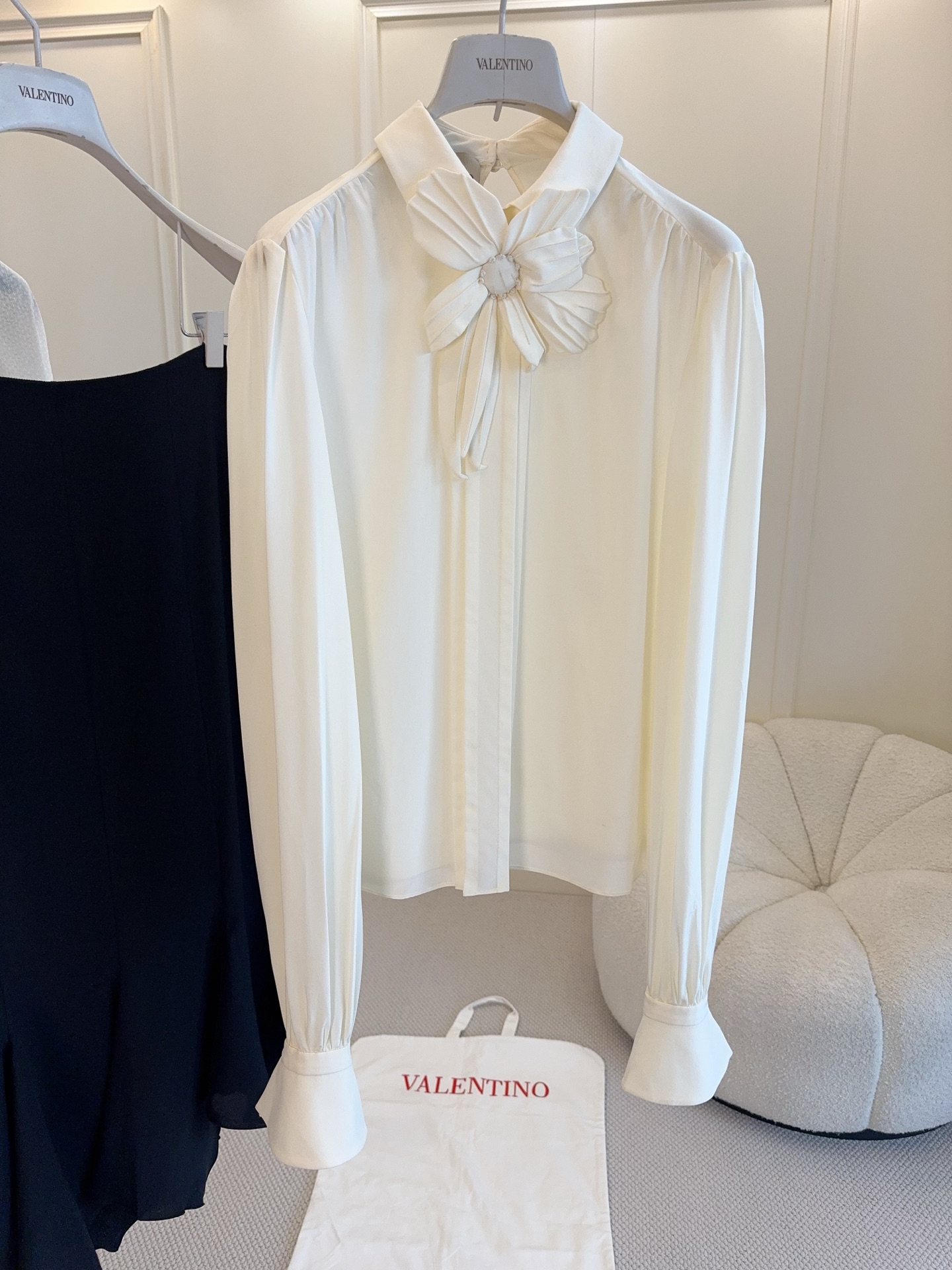 NO:804683,Valentino2026 new off-white silk three-dimensional flower shirt, real silk, silky and shiny, perfect drape. Three-dimensional handmade flowers on the neckline, exquisite and elegant, full of French romantic atmosphere!  The long sleeves have micro-flared cuffs, are retro and feminine, and can be easily worn for commuting, dating, and formal occasions. Paired with a black skirt or high-waisted pants, it will instantly enhance your temperament. It is a must-have and versatile item in your wardrobe!  ,,valentino,skirts,shirts,real silk,19860909Valentino2026新款米白色真丝立体花朵衬衫,真丝,丝滑有光泽,垂坠感满分.领口立体手工花朵,精致优雅,法式浪漫氛围拉满！长袖微喇叭袖口,复古又柔美,通勤、约会、正式场合都能轻松驾驭.搭配黑色半裙或高腰裤,气质直接拉满,是衣橱必备百搭单品！,,valentino,skirts,shirts,real silk,,Women's clothing