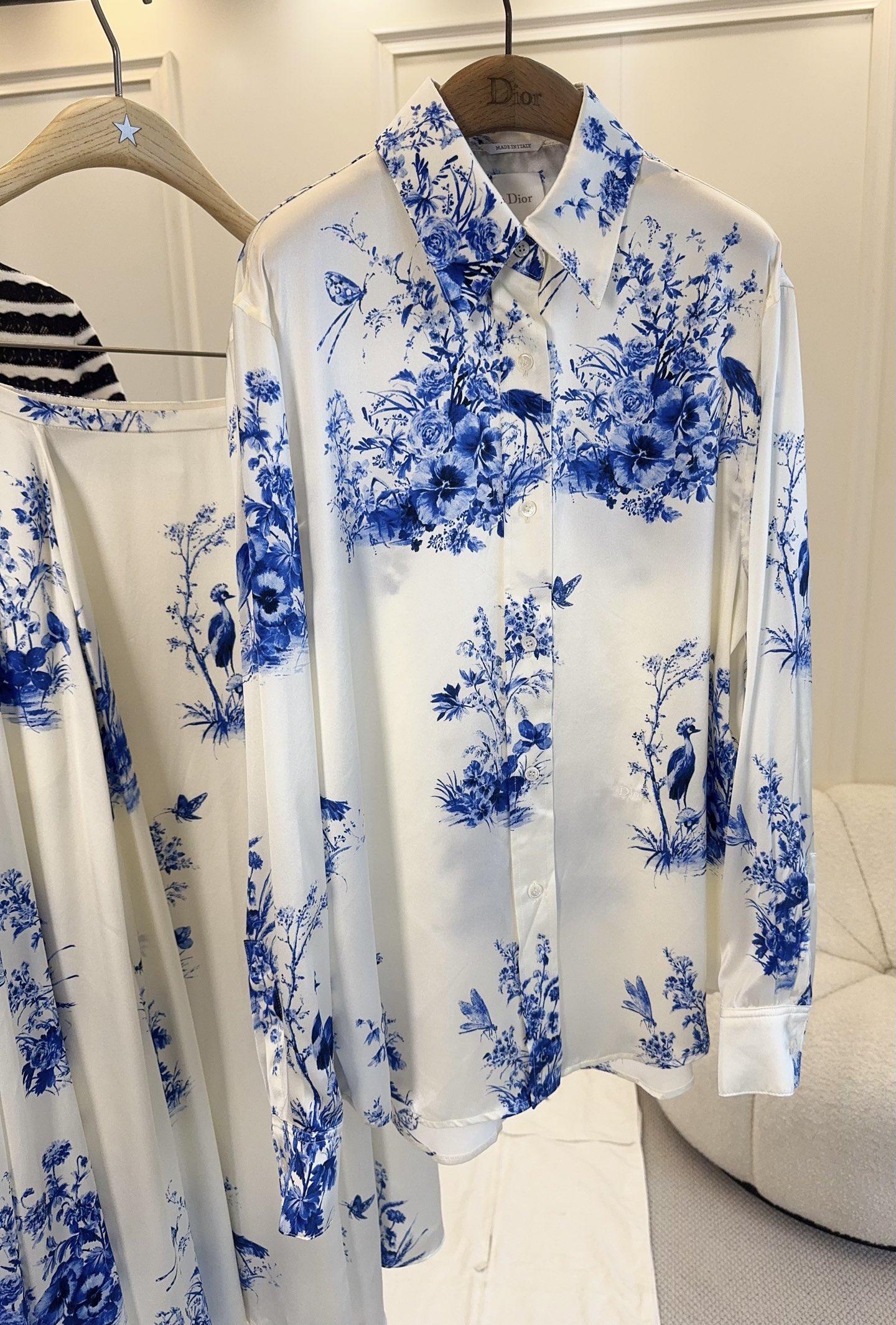 NO:827748,shirt  Skirt pDior2026 new blue and white porcelain print suit, the white background blue flower design is inspired by oriental ink painting, full of artistic sense. Mulberry silk fabric, great drape and gloss, comfortable and high-end to wear. The shirt has a classic lapel, and the CD button is super delicate;  The high-waisted A-line skirt has an elegant and flexible hem. The skirt is made of ultra-luxury materials and has a large hem, which modifies the body proportions. It can be easily controlled for daily commuting, dating, and vacations, and the elegant atmosphere is directly filled.,, dior, skirts, shirts,19860909衬衫 半裙pDior2026新款青花瓷印花套装,白底蓝花设计灵感源自东方水墨画,艺术感满满.桑蚕丝面料,垂坠感和光泽度都很赞,穿着舒适又高级.衬衫是经典翻领,CD纽扣超精致；半身裙高腰A字版型,裙摆飘逸灵动,半裙超奢用料,度大裙摆,修饰身材比例.日常通勤、约会、度假都能轻松驾驭,优雅氛围感直接拉满.,,dior,skirts,shirts,,Women's clothing