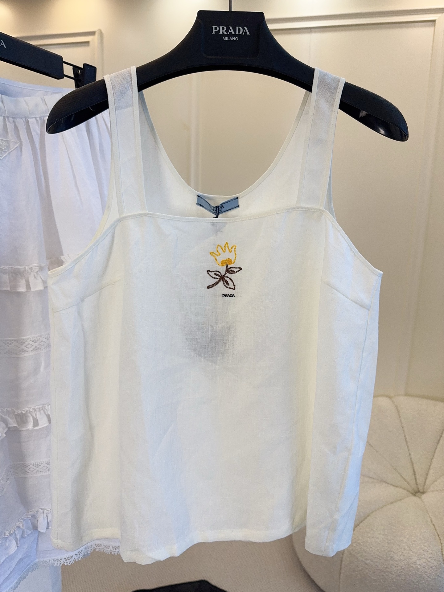 NO:838370,Prada's 2026 new White Sun series linen suspenders are made of white linen, which is light and breathable and super comfortable to wear in spring and summer!  Exquisite floral embroidery + brand letters on the chest, full of details. The sleeveless design is simple and fresh, versatile to wear alone or layered, and can be easily used for daily outings, vacations, and light formal occasions. Linen has natural wrinkles, casual and textured, and is a must-have item in the summer wardrobe!  ,,prada,19860909Prada 2026新款White Sun系列亚麻吊带,选用白色亚麻材质,轻盈透气,春夏穿超舒服！胸前精致花卉刺绣+品牌字母,细节满分.无袖设计简约清新,单穿或叠搭都很百搭,日常出街、度假、轻正式场合都能轻松驾驭.亚麻自带自然褶皱,随性又有质感,是夏日衣橱必备单品！,,prada,,Women's clothing