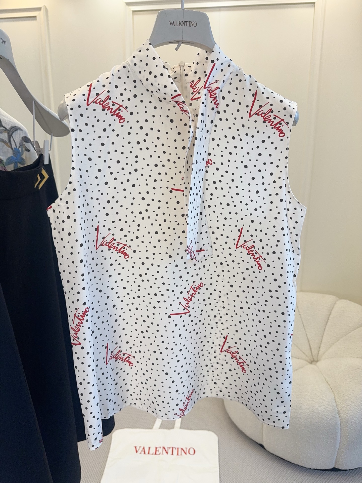 NO:840256,Valentino 2026 early autumn new series sleeveless shirt, silk, white base with black polka dots + red brand letters, highly recognizable. Super breathable for spring and summer, stand-up collar and ribbon sleeveless design, elegant and casual, good to wear alone or layered with!  It can be easily worn for daily commuting and vacation. Pair it with high-waisted pants or skirts for a perfect fashion sense.,,valentino,skirts,shirts,real silk,19860909Valentino 2026早秋新款系列无袖衬衫,真丝,白色底配黑色波点+红色品牌字母,辨识度超高.春夏穿超透气,立领飘带无袖设计,优雅又休闲,单穿或内搭都很OK！日常通勤、度假都能轻松驾驭,搭配高腰裤或半裙,时髦感满分.,,valentino,skirts,shirts,real silk,,Women's clothing