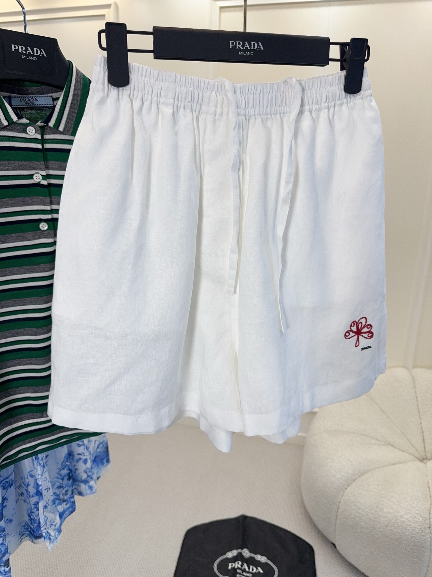 NO:867334,Prada 2026 new white linen shorts, linen is breathable and light, super comfortable to wear in spring and summer!  The loose fit + drawstring design is casual and practical, and the red embroidered logo on the hem is very recognizable. The linen has natural wrinkles and a perfect lazy atmosphere. It can be easily used for commuting and vacation. It is a versatile wardrobe item!  ,,prada,shorts,19860909Prada2026新款白色亚麻短裤,亚麻透气轻盈,春夏穿超舒服！宽松版型+抽绳设计,随性又实用,裤脚红色刺绣徽标超有辨识度.亚麻自带自然褶皱,慵懒氛围感满分,通勤、度假都能轻松驾驭,是衣橱百搭神器！,,prada,shorts,,Women's clothing