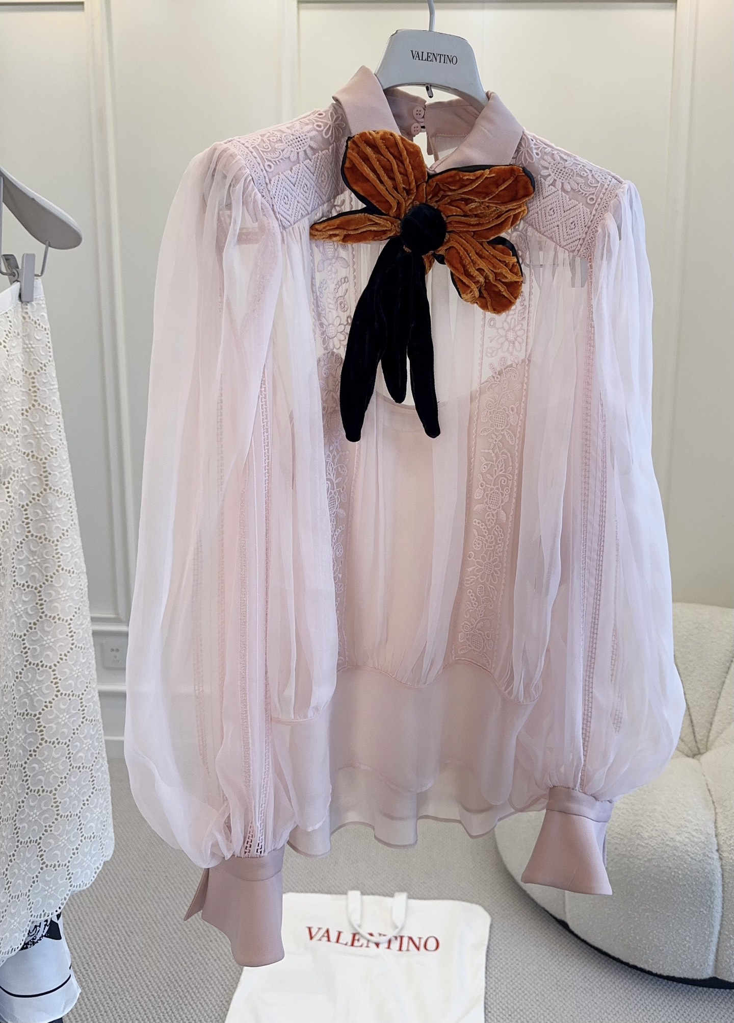 NO:868559,Valentino 2026 new pink silk embroidered shirt, inspired by the theme of 'Fireflies', light gauze texture, full of romantic elegance. Velvet bow on the chest, brown and black contrasting colors are super layered, lantern sleeve design is retro and feminine, and the cuff pleat details are very delicate. The overall cut is loose, comfortable and fashionable, and can be easily worn in daily or formal occasions. Paired with high-waisted pants/skirts, you can easily get a high-end look.,,valentino,skirts,shirts,real silk,19860909Valentino 2026新款粉色真丝刺绣衬衫,灵感来自“萤火虫”主题,轻薄纱质,浪漫优雅满分.胸前丝绒蝴蝶结,棕黑撞色超有层次感,灯笼袖设计复古又柔美,袖口褶皱细节很精致.整体剪裁宽松,舒适又时髦,日常或正式场合都能轻松驾驭,搭配高腰裤/裙装,轻松get高级感look.,,valentino,skirts,shirts,real silk,,Women's clothing