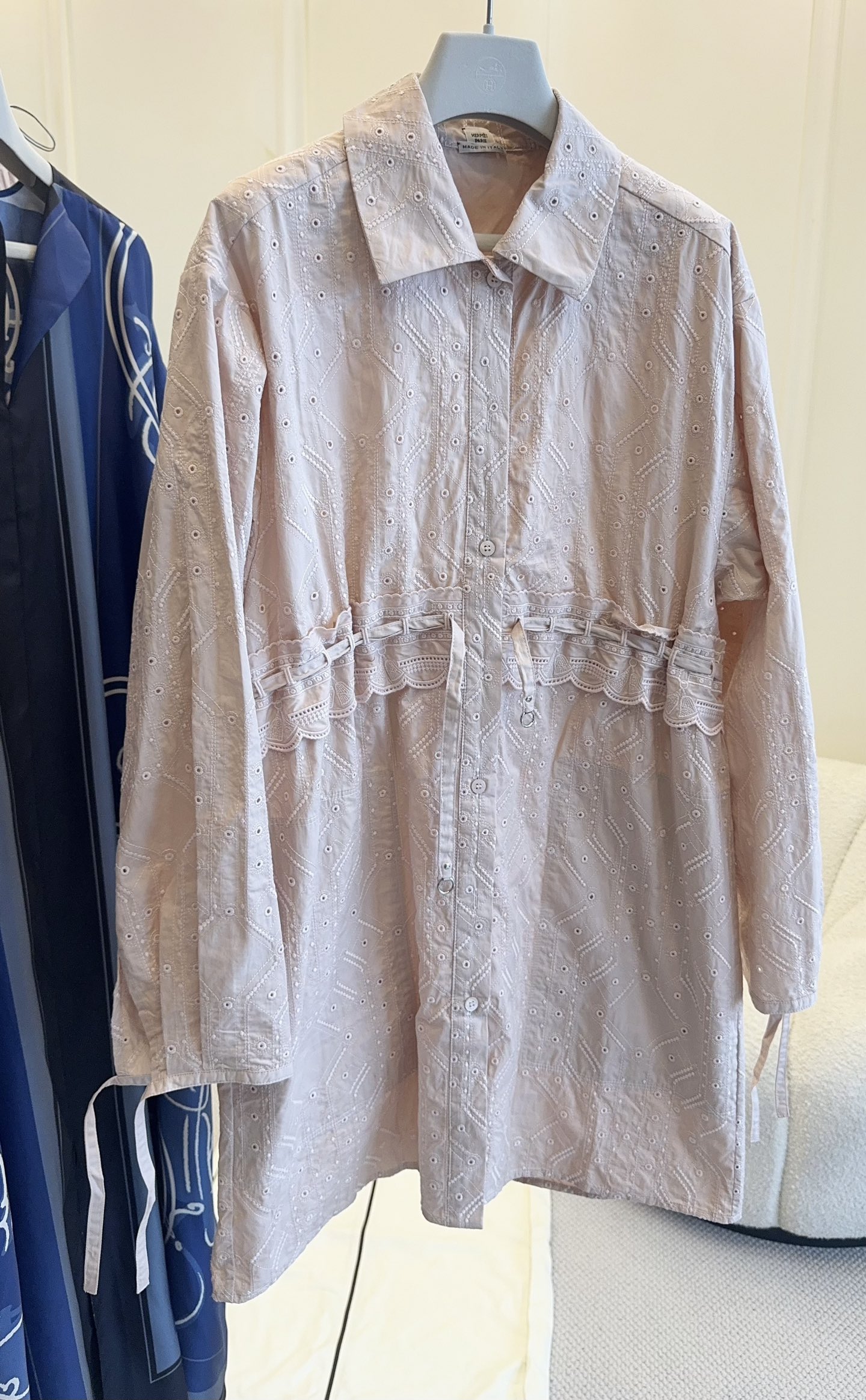 NO:869807,Hermes 2026 new embroidered shirt skirt, classic lapel + single-breasted design, simple and neat; lace splicing on the waist + drawstring tie, the elasticity can be adjusted freely, easily creating a casual waistline, hiding the muscles and making you look slimmer. Gentle nude pink embroidery, wear the spring atmosphere on the body, long shirt with a lazy and relaxed feeling  The skirt has a gentle nude pink tone, a low saturation color that doesn't pick on the skin tone, and comes with a soft filter for daily wear. The whole body has exquisite hollow embroidery patterns, and the delicate texture is full, and every small hole reveals a breathable texture. It is refreshing and not stuffy to wear in spring and summer, and has both good looks and practical wear.,, hermes, skirts, shirts,19860909Hermes2026新款刺绣衬衫裙,经典翻领+单排扣设计,简约利落；腰侧蕾丝花边拼接+抽绳系带,可自由调节松紧,轻松打造随性腰线,藏肉显瘦.温柔裸粉刺绣,把春日氛围感穿在身上,自带慵懒松弛感的长款衬衫裙,温柔裸粉色调,低饱和色系不挑肤色,日常穿自带柔和滤镜.通体精致镂空刺绣纹样,细腻肌理感拉满,每一处小孔都透着透气质感,春夏穿清爽不闷,兼具颜值与实穿性.,,hermes,skirts,shirts,,Women's clothing