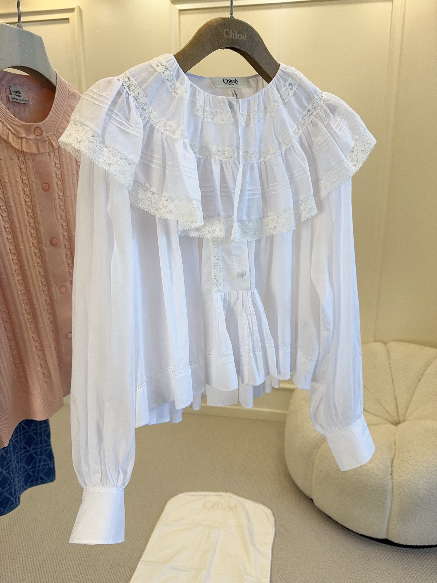 NO:877324,Chloé's 2026 new ruffled white shirt is full of French elegance. The light and breathable fabric is perfect for spring and summer!  The doll collar + ruffle design directly enhances the sense of layering and femininity. The cape style, which is short in the front and long in the back, modifies the body shape and makes it appear loose, and the cuffs are slightly tapered to make it more refined. It looks great with a high-waisted skirt or jeans, and can be easily used for commuting, dating, and daily life. It is a must-have and versatile item for the spring and summer wardrobe!  ,,chloe,skirts,jeans,shirts,19860909Chloé2026新款荷叶边白衬衫,法式优雅风满满,轻薄透气面料超适合春夏！娃娃领+荷叶边设计,层次感和柔美气质直接拉满.前短后长斗篷版型,修饰身形又显松弛,袖口微收更显精致.搭配高腰裙or牛仔裤都超好看,通勤、约会、日常都能轻松驾驭,是春夏衣橱必备百搭单品！,,chloe,skirts,jeans,shirts,,Women's clothing