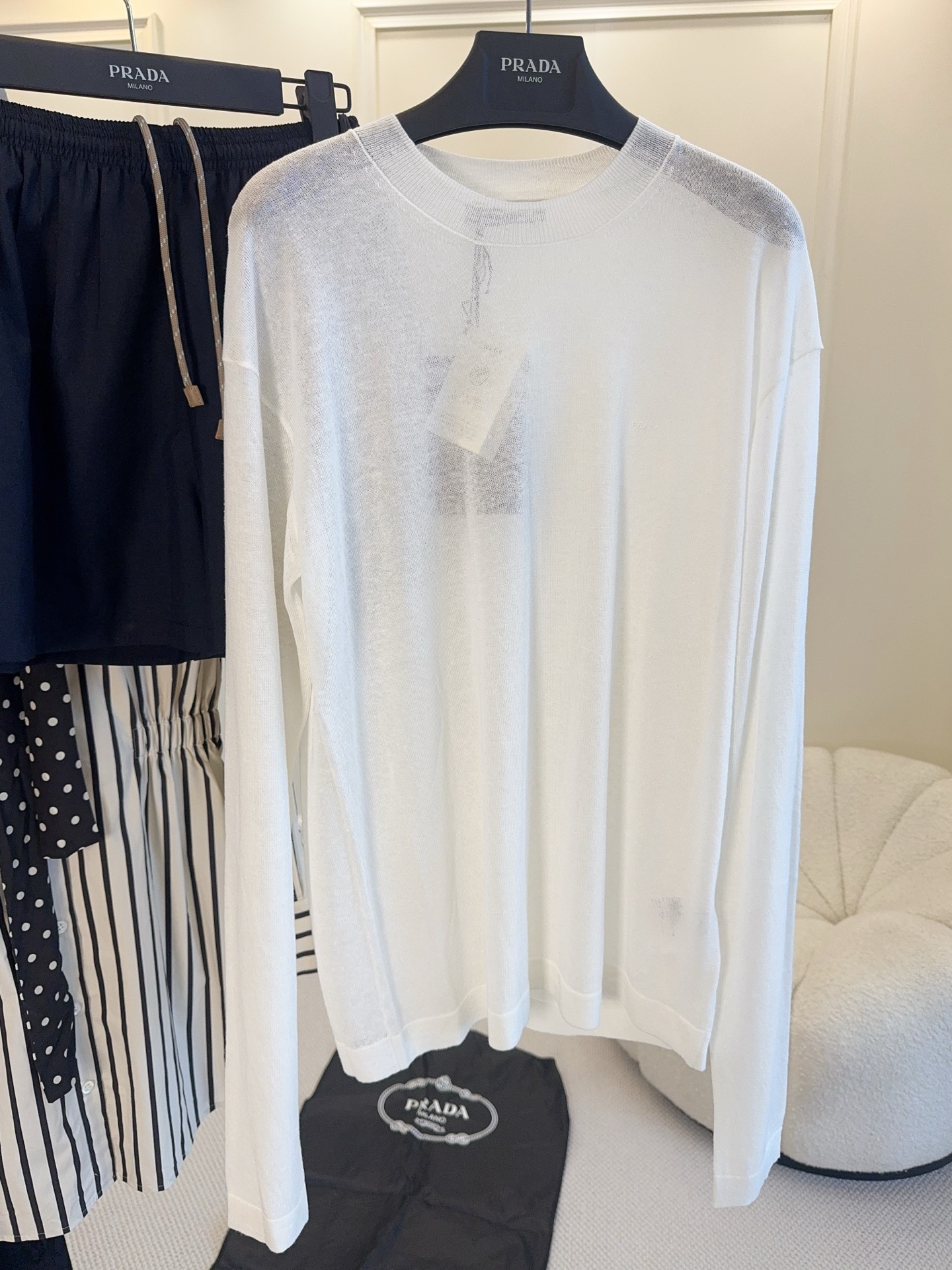 NO:893084,Prada's 2026 new long-sleeved white T-shirt is made of linen blended fabric, breathable and comfortable, perfect for spring and summer!  The loose dropped shoulder design is lazy and casual. The white color is low in saturation and is versatile regardless of skin color. The fabric has natural wrinkles and perfect texture, which can be easily used for daily commuting and vacation. Paired with wide-leg pants or skirts, you can easily get a sense of relaxation and look stylish no matter how you wear it!  ,,prada,skirts,19860909Prada2026新款长袖白T,采用亚麻混纺面料,透气又舒适,春夏穿超合适！宽松落肩设计,慵懒随性,白色低饱和度,百搭不挑肤色.面料自带自然褶皱,质感满分,日常通勤、度假都能轻松驾驭.搭配阔腿裤或半裙,轻松get松弛感穿搭,怎么搭都很有型！,,prada,skirts,,Women's clothing