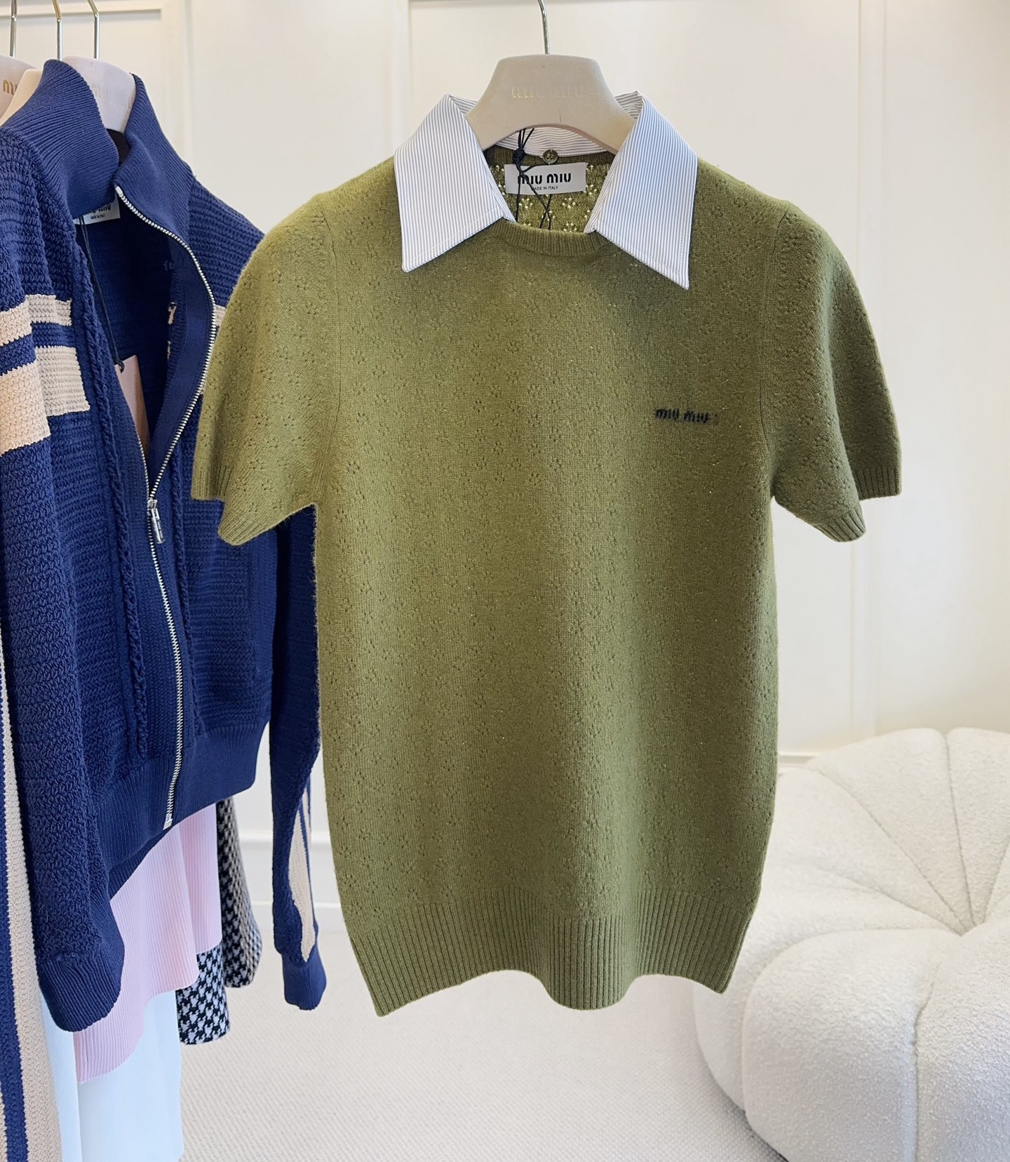 NO:909197,MiuMiu2026 new olive green hollow knitted short-sleeves, paired with a detachable white shirt collar, full of retro college style!  Slightly slim cut + ribbed hem, showing the waistline and fitting the body shape. The 'MiuMiu' embroidery on the left chest is low-key and exquisite, which can be easily controlled for daily commuting, dating, and leisure. Paired with a work skirt or high-waisted pants, the layering and fashion sense are directly enhanced.,,miumiu,skirts,shirts,T-shirt,19860909MiuMiu2026新款橄榄绿镂空针织短袖,搭配可拆卸白衬衫领,复古学院风满满！微修身剪裁+罗纹下摆,显腰线又贴合身形.左胸“MiuMiu”刺绣低调精致,日常通勤、约会、休闲都能轻松驾驭,搭配工装裙或高腰裤,层次感和时尚感直接拉满.,,miumiu,skirts,shirts,T-shirt,,Women's clothing