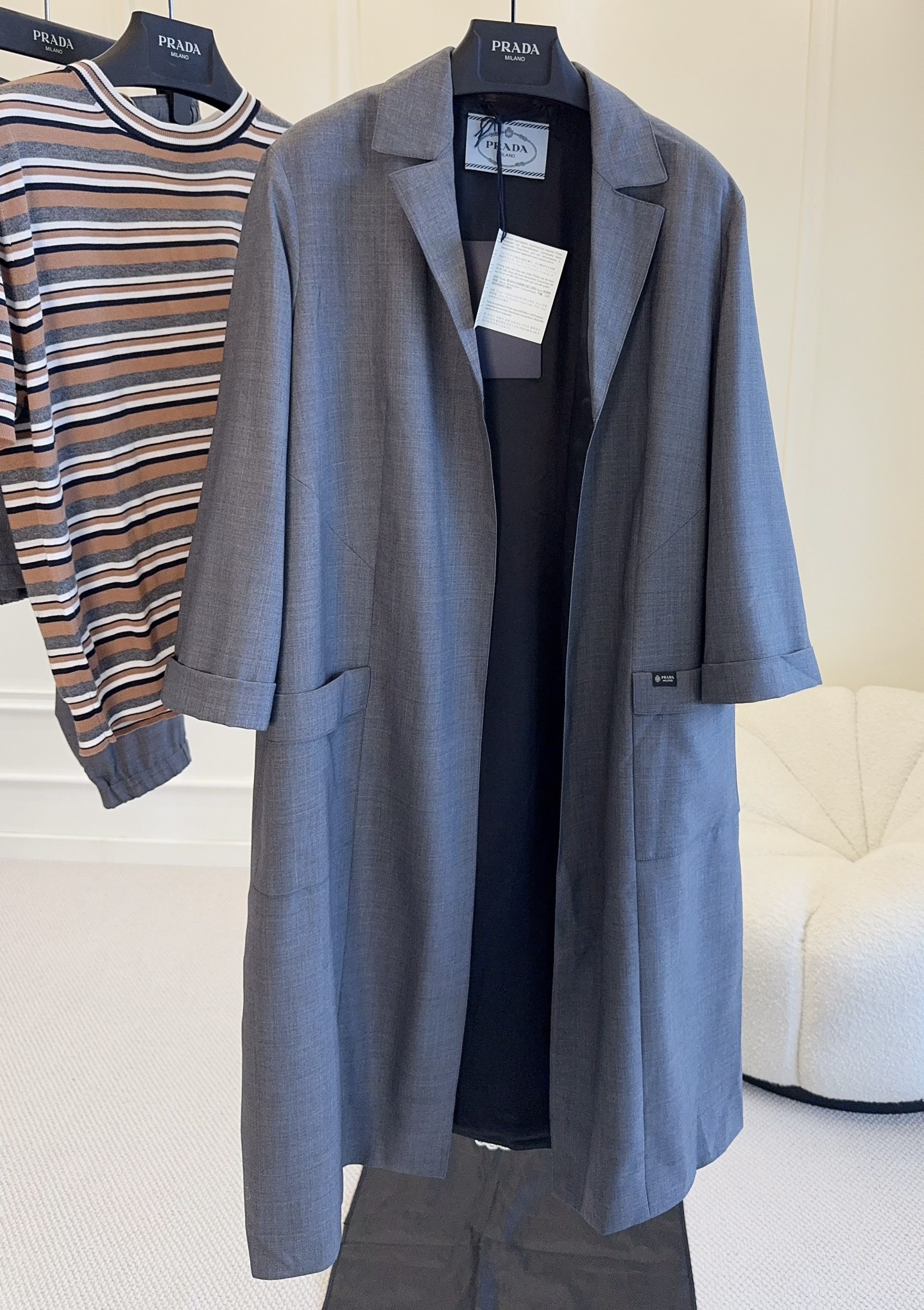 NO:911219,Prada 2026 new gray bathrobe windbreaker, wool blend, soft and crisp, super comfortable to wear in autumn and winter!  The lapels + loose tailoring are casual and elegant, and the details on the cuffs and hem are very delicate. The gray color is low-key and gentle, and can be easily used for commuting and parties. It can also modify the figure when paired with a belt. It is practical and fashionable. It is a must-have and versatile item for autumn and winter wardrobes!  ,,prada,19860909Prada2026新款灰色浴袍风衣,羊毛混纺,柔软又挺括,秋冬穿超舒服！翻领+宽松剪裁,随性优雅,袖口和下摆细节很精致.灰色低调温柔,通勤、聚会都能轻松驾驭,搭配腰带还能修饰身形,实用又时髦,是秋冬衣橱必备百搭单品！,,prada,,Women's clothing
