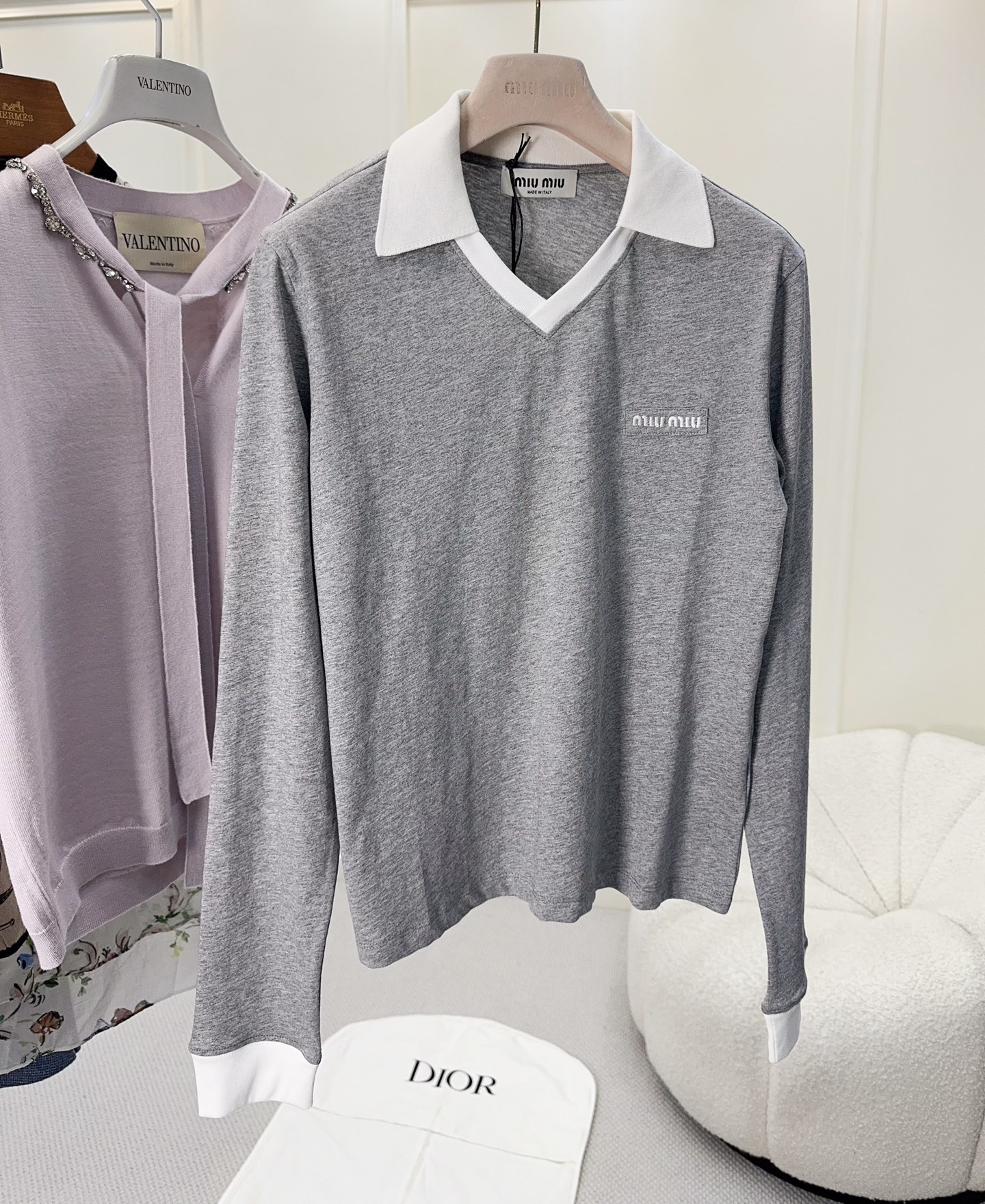 NO:923997,Miu Miu 2026 new gray fake two-piece sweater, pure cotton is soft and comfortable, gray main color + white lapels and cuffs, the fake two-piece design is full of layers and full of college style. The small logo on the chest is low-key and recognizable, and the fit is slim. It is OK to wear alone or layered with shirts. It can be easily used for commuting and leisure. It is a practical and fashionable versatile item!  ,,miumiu,shirts,19860909Miu Miu2026新款灰色假两件针织衫,纯棉柔软舒适,灰色主色+白色翻领和袖口,假两件设计层次感满满,学院风十足.胸前小Logo低调有辨识度,版型修身,单穿或叠搭衬衫都很OK,通勤休闲都能轻松驾驭,是实用又时髦的百搭单品！,,miumiu,shirts,,Women's clothing