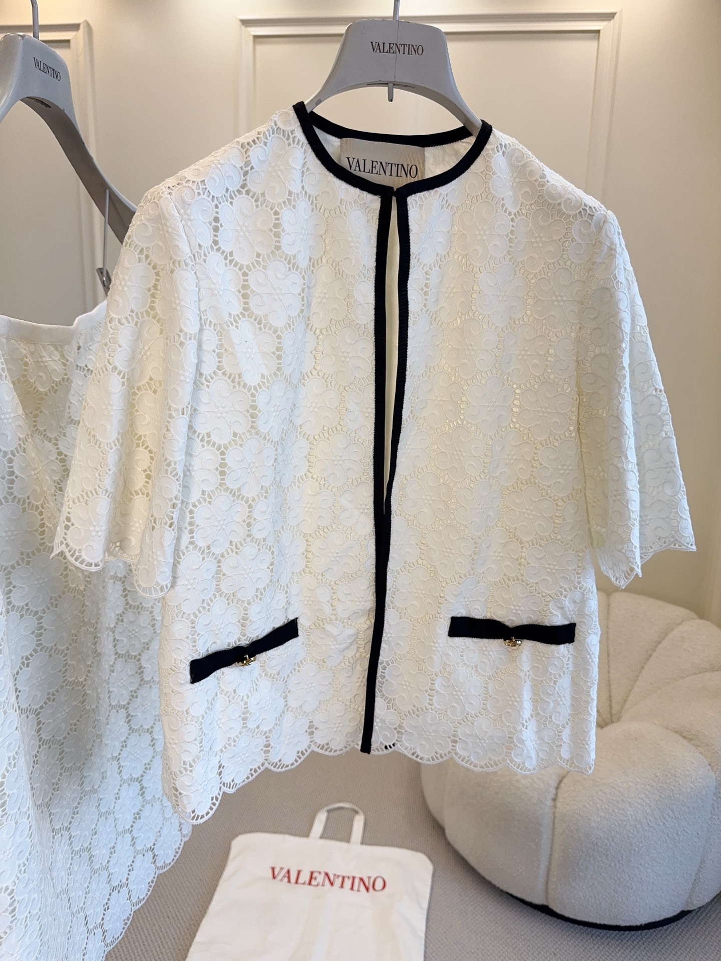 NO:923953,Jacket and skirt Valentino 2026 new white lace suit, short-sleeved jacket + skirt, the hexagonal lace texture is super exquisite, black piping embellishment, elegant and modern. The jacket is neatly cut, and the skirt is of moderate length, which can be easily used for commuting or formal occasions. The lace material is breathable and comfortable, perfect for early autumn~ Paired with simple inner wear and handbags, it will directly enhance your temperament!  ,,valentino,skirts,jackets & coats,T-shirt,19860909外套 半裙Valentino2026新款白色蕾丝套装,短袖外套+半裙,六边形蕾丝纹理超精致,黑色滚边点缀,优雅又现代.外套剪裁利落,半裙长度适中,通勤或正式场合都能轻松驾驭.蕾丝材质透气舒适,早秋穿超合适～搭配简约内搭和手袋,气质直接拉满！,,valentino,skirts,jackets & coats,T-shirt,,Women's clothing