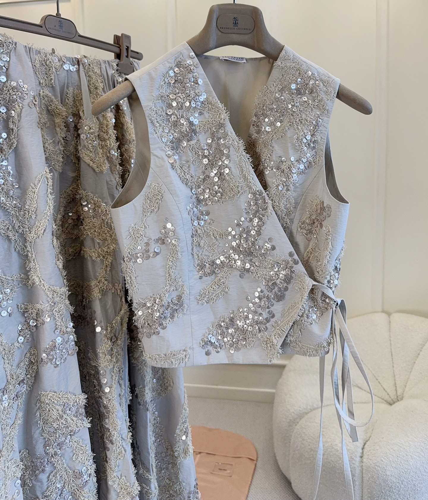 NO:934336,Brunello Cucinelli 2026 new embroidered sequin vest, off-white base + exquisite sequin embroidery, full of low-key luxury!  Cotton + nylon blend, soft and crisp, super comfortable to wear ~ The V-neck modifies the neck line, and the side straps are adjustable for elasticity, making it slim and feminine. The three-dimensional embroidery pattern all over the body has a shimmering luster under the light. Pair it with a white T or linen skirt, and you can easily get old money style or fairy style!  ,,brunello cucinelli,skirts,19860909Brunello Cucinelli2026新款刺绣亮片马甲,米白色基底+精致亮片刺绣,低调奢华感满满！棉+锦纶混纺,柔软又挺括,穿着超舒适～V领修饰颈部线条,侧边系带可调节松紧,显瘦又柔美.满身立体刺绣花纹,光线下细碎光泽,搭配白T或亚麻裙,轻松get老钱风or仙气穿搭！,,brunello cucinelli,skirts,,Women's clothing