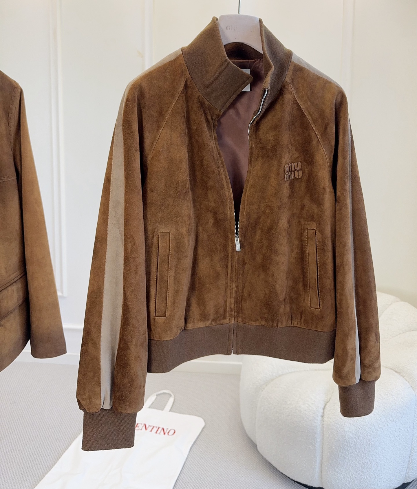 NO:945914,Miu Miu's new 2026 autumn and winter suede baseball jacket is made of imported suede with super high-end texture. Caramel color matching + three-dimensional embossed logo, full of retro sports style!  The loose fit and zipper design make it super convenient for daily wear. It looks great with a tube top skirt or jeans. You can easily get an American campus style or a relaxed look. It is a must-have and versatile item in your wardrobe!  ,,miumiu,skirts,jeans,jackets & coats,chamois leather,19860909Miu Miu2026秋冬新款麂皮棒球夹克,选用进口麂皮,质感超高级.焦糖色配色+立体压花Logo,复古运动风满满！宽松版型,拉链设计,日常穿搭超方便,随便搭抹胸裙or牛仔裤都很出彩,轻松get美式校园风or松弛感穿搭.是衣橱必备百搭单品！,,miumiu,skirts,jeans,jackets & coats,chamois leather,,Women's clothing