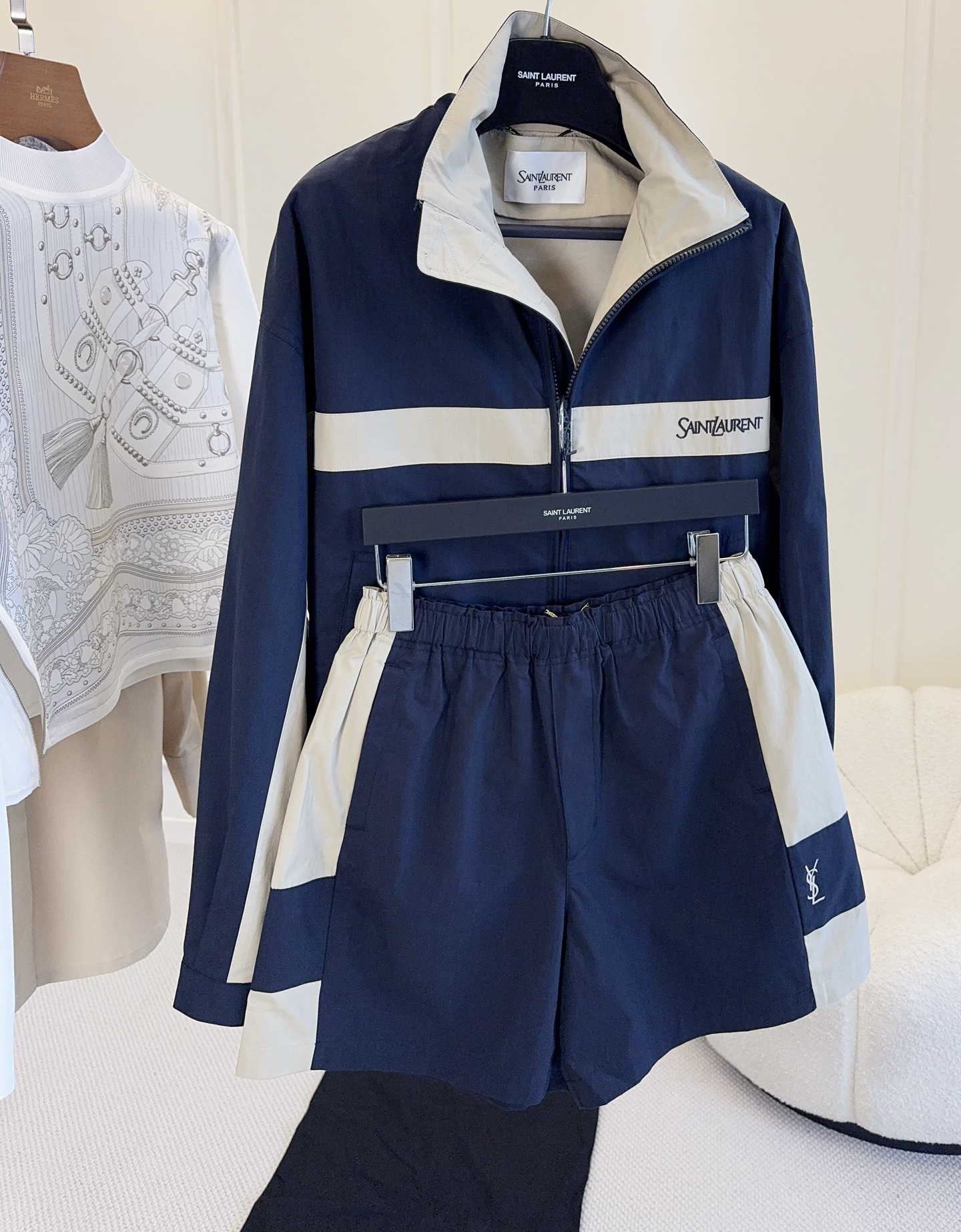 NO:946076,Jacket Shorts YSL 2026 new autumn and winter series navy blue color-blocked sports jacket, made of cotton canvas, stand-up collar + zipper design, full of retro sports style!  The main color is navy blue with off-white stripes, which combines a college feel with a sense of urban relaxation. The 'YSL' embroidery on the chest is very recognizable, and the style is the same for both men and women. It can be easily used for daily outings and casual occasions. It is casual and high-end when paired with shorts, making it easy to achieve a fashionable feel!  ,,saint laurent,shorts,jackets & coats,jackets & coats,19860909外套 短裤YSL 2026新款秋冬系列藏青拼色运动夹克,棉质帆布材质,立领+拉链设计,复古运动风满满！藏青主色配米白条纹,学院感与都市松弛感兼具.胸前“YSL”刺绣超有辨识度,男女同款,日常出街、休闲场合都能轻松驾驭,搭配短裤随性又高级,轻松拿捏时髦感！,,saint laurent,shorts,jackets & coats,jackets & coats,,Women's clothing