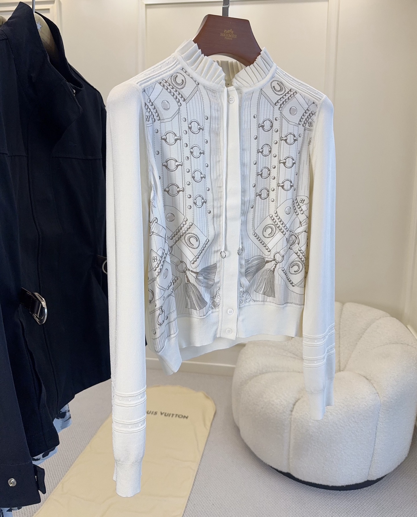 NO:954813,Hermès  2926 new silk print splicing knitted cardigan, French elegant ceiling classic equestrian harness silk print, exquisite and restrained gray lines, integrated with the brand's iconic saddle and tassel patterns, full of retro aesthetics. The stand-up collar pleated lace design has a gentle temperament; the front piece is spliced with silk print, and the sides and sleeves are made of fine knitted fabrics, which balances rigidity and softness. Single row  Button closure, short cut to optimize body proportions, textured seaming details on the cuffs, and exquisite craftsmanship. The milky white base is clean and soft, and the knitting is soft and skin-friendly. It is suitable for both spring and autumn wear alone and as an inner layer in winter. Without too much matching, it is easy to wear the unique low-key elegance of Hermès, and can be used for commuting and afternoon tea.,, hermes, hermes, real  silk,19860909Hermès 2926新款真丝印花拼接针织开衫,法式优雅天花板经典马术马具真丝印花,灰调线条精致内敛,融合品牌标志性马鞍、流苏纹样,充满复古美学.立领褶皱花边设计,自带温婉气质；前片真丝印花拼接,两侧与袖子采用细腻针织面料,刚柔平衡.单排纽扣开合,短款剪裁优化身材比例,袖口做肌理压线细节,工艺考究.奶白基底干净柔和,针织软糯亲肤,春秋单穿、冬季内搭都适配.无需过多搭配,轻松穿出爱马仕独有的低调贵气,通勤下午茶皆可驾驭.,,hermes,hermes,real silk,,Women's clothing