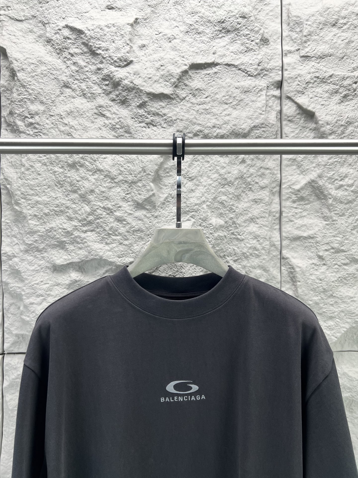 Balenciaga BALENCI*GA 灰圈刺绣圆领短袖 用24S双纱 平纹针织面料 32S双纱1*1 螺纹 300克24S面料属于中等偏粗的纱线 适合打造厚实 挺括的面料 质感略带粗糙感 符合 风格追求的“自然原始”效果 质地柔软 透气且有一定弹性 适合贴身穿着 能塑造简约流畅的轮廓 通过做旧纹理 褪色处理 结合 剪裁体现 感宽松廓形设计细节 整体走线平直细腻 面料舒适柔软 颜色一致无色差 能与同款搭配营造 造型 驾驭各种场合 定制辅料 三标齐全