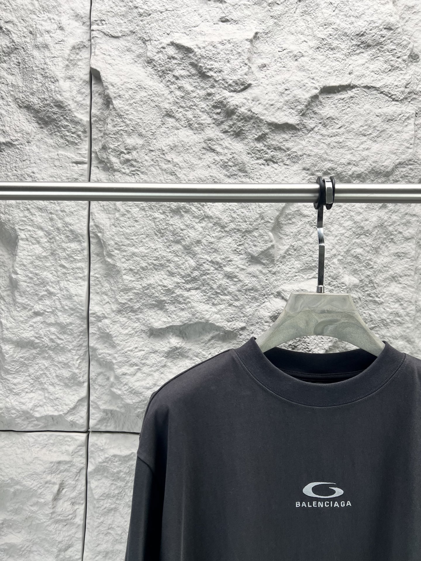 Balenciaga BALENCI*GA 灰圈刺绣圆领短袖 用24S双纱 平纹针织面料 32S双纱1*1 螺纹 300克24S面料属于中等偏粗的纱线 适合打造厚实 挺括的面料 质感略带粗糙感 符合 风格追求的“自然原始”效果 质地柔软 透气且有一定弹性 适合贴身穿着 能塑造简约流畅的轮廓 通过做旧纹理 褪色处理 结合 剪裁体现 感宽松廓形设计细节 整体走线平直细腻 面料舒适柔软 颜色一致无色差 能与同款搭配营造 造型 驾驭各种场合 定制辅料 三标齐全