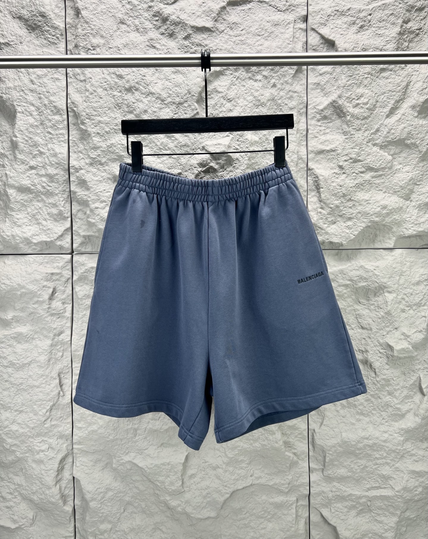 Balenciaga BALENCI*GA logo刺绣短裤这款白色休闲短裤采用重磅精梳棉混纺面料 经预缩与磨毛处理 布面呈现细腻绒感 亲肤透气且不易变形 腰头采用多道抽褶松紧带工艺 内置高弹橡筋与扁平抽绳 可自由调节松紧度 穿着无束缚感 裤身采用立体剪裁 侧缝与内缝使用双线包边工艺 牢固耐穿且避免线头外露 左裤腿处采用进口电脑刺绣工艺 精准绣制品牌字母标识 针脚细密平整 色彩饱和度高且不易脱落 裤脚采用双针卷边锁缝工艺 边缘平整挺括 视觉上更显利落 适配日常休闲 运动等多种场景 兼具实用性与潮流质感 整体走线平直细腻 面料舒适柔软 颜色一致无色差 能与同款搭配营造 造型 驾驭各种场合 定制辅料 三标齐全