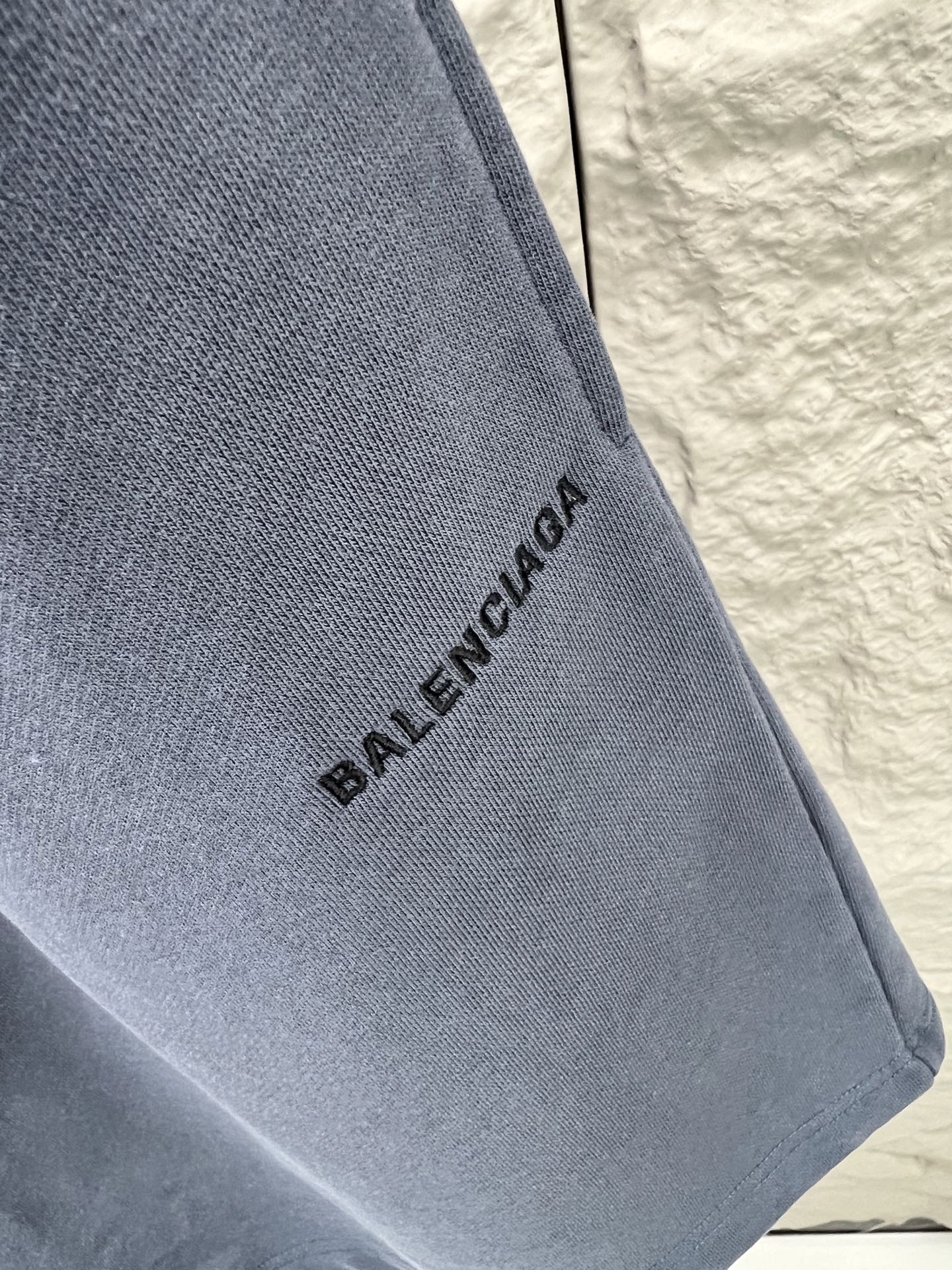 Balenciaga BALENCI*GA logo刺绣短裤这款白色休闲短裤采用重磅精梳棉混纺面料 经预缩与磨毛处理 布面呈现细腻绒感 亲肤透气且不易变形 腰头采用多道抽褶松紧带工艺 内置高弹橡筋与扁平抽绳 可自由调节松紧度 穿着无束缚感 裤身采用立体剪裁 侧缝与内缝使用双线包边工艺 牢固耐穿且避免线头外露 左裤腿处采用进口电脑刺绣工艺 精准绣制品牌字母标识 针脚细密平整 色彩饱和度高且不易脱落 裤脚采用双针卷边锁缝工艺 边缘平整挺括 视觉上更显利落 适配日常休闲 运动等多种场景 兼具实用性与潮流质感 整体走线平直细腻 面料舒适柔软 颜色一致无色差 能与同款搭配营造 造型 驾驭各种场合 定制辅料 三标齐全