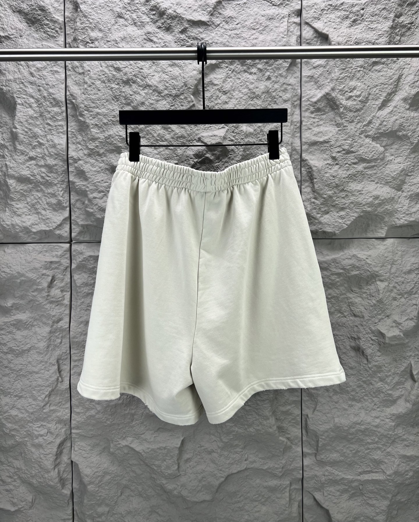 Balenciaga BALENCI*GA logo刺绣短裤这款白色休闲短裤采用重磅精梳棉混纺面料 经预缩与磨毛处理 布面呈现细腻绒感 亲肤透气且不易变形 腰头采用多道抽褶松紧带工艺 内置高弹橡筋与扁平抽绳 可自由调节松紧度 穿着无束缚感 裤身采用立体剪裁 侧缝与内缝使用双线包边工艺 牢固耐穿且避免线头外露 左裤腿处采用进口电脑刺绣工艺 精准绣制品牌字母标识 针脚细密平整 色彩饱和度高且不易脱落 裤脚采用双针卷边锁缝工艺 边缘平整挺括 视觉上更显利落 适配日常休闲 运动等多种场景 兼具实用性与潮流质感 整体走线平直细腻 面料舒适柔软 颜色一致无色差 能与同款搭配营造 造型 驾驭各种场合 定制辅料 三标齐全