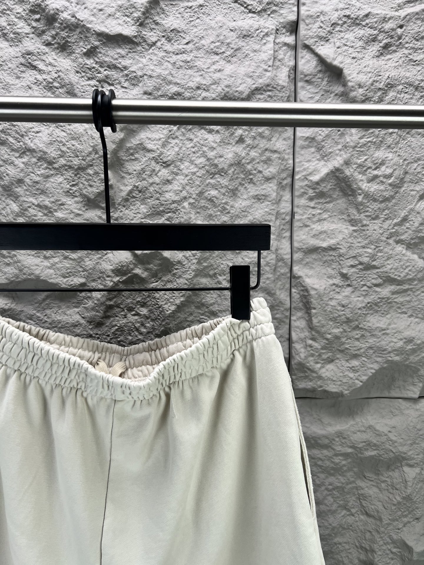 Balenciaga BALENCI*GA logo刺绣短裤这款白色休闲短裤采用重磅精梳棉混纺面料 经预缩与磨毛处理 布面呈现细腻绒感 亲肤透气且不易变形 腰头采用多道抽褶松紧带工艺 内置高弹橡筋与扁平抽绳 可自由调节松紧度 穿着无束缚感 裤身采用立体剪裁 侧缝与内缝使用双线包边工艺 牢固耐穿且避免线头外露 左裤腿处采用进口电脑刺绣工艺 精准绣制品牌字母标识 针脚细密平整 色彩饱和度高且不易脱落 裤脚采用双针卷边锁缝工艺 边缘平整挺括 视觉上更显利落 适配日常休闲 运动等多种场景 兼具实用性与潮流质感 整体走线平直细腻 面料舒适柔软 颜色一致无色差 能与同款搭配营造 造型 驾驭各种场合 定制辅料 三标齐全