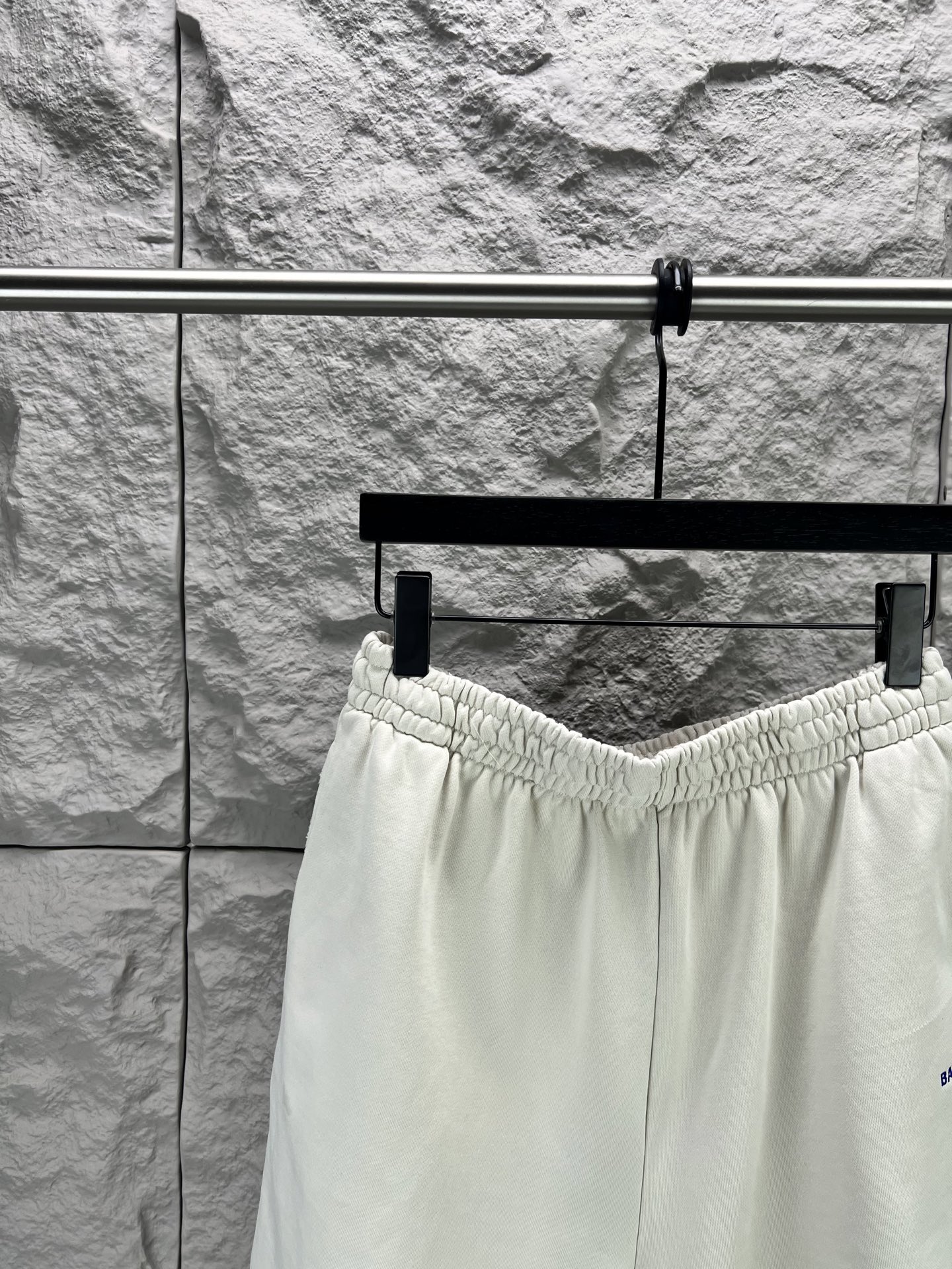 Balenciaga BALENCI*GA logo刺绣短裤这款白色休闲短裤采用重磅精梳棉混纺面料 经预缩与磨毛处理 布面呈现细腻绒感 亲肤透气且不易变形 腰头采用多道抽褶松紧带工艺 内置高弹橡筋与扁平抽绳 可自由调节松紧度 穿着无束缚感 裤身采用立体剪裁 侧缝与内缝使用双线包边工艺 牢固耐穿且避免线头外露 左裤腿处采用进口电脑刺绣工艺 精准绣制品牌字母标识 针脚细密平整 色彩饱和度高且不易脱落 裤脚采用双针卷边锁缝工艺 边缘平整挺括 视觉上更显利落 适配日常休闲 运动等多种场景 兼具实用性与潮流质感 整体走线平直细腻 面料舒适柔软 颜色一致无色差 能与同款搭配营造 造型 驾驭各种场合 定制辅料 三标齐全
