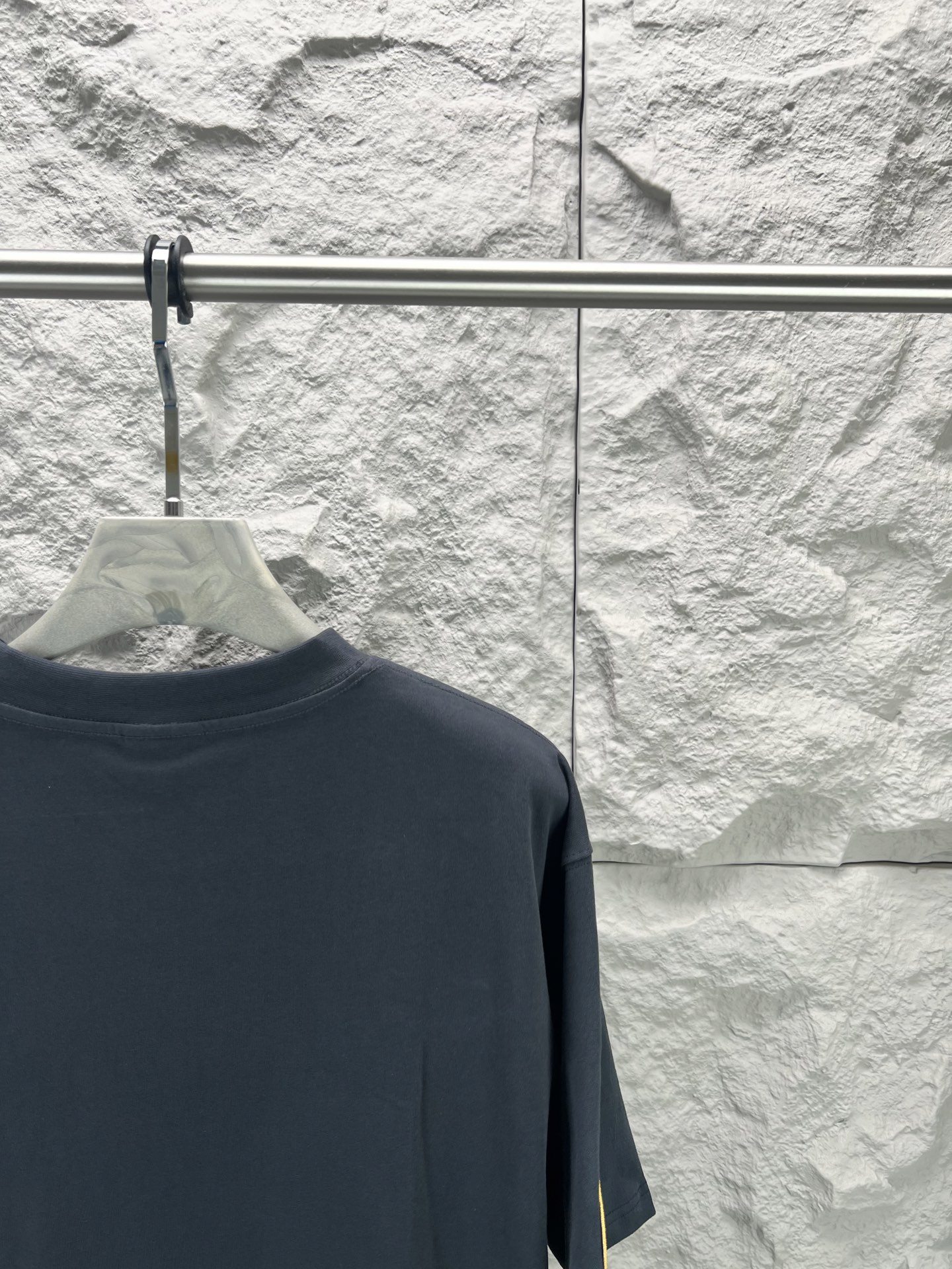 Vetements 胸前字母狮标徽章短袖280克精棉平纹面料 双纱拉架罗纹 平纹纯棉面料是一种高质量的棉纺织品 具有紧密的纺纱技术和高支数 这种面料具有柔软 舒适 透气和吸湿性好等特点 同时其纺织工艺要求也较高 纯棉质织物组织结构为平纹 面料的织物表面平整细腻 质地紧密 具有良好的吸湿透气性和舒适性 能够保持干爽舒适 由于其紧密的纺纱工艺 徽标刺绣章仔点缀 徽标采用进口定做绣线具有光泽感的丝光绣线进行定染 精细的细节处理 造就了立体微浮雕的刺绣效果 哑光挨针刺绣工艺是一种刺绣技术 颜色一致无色差 能与同款搭配营造 造型 驾驭各种场合 定制辅料 三标齐全
