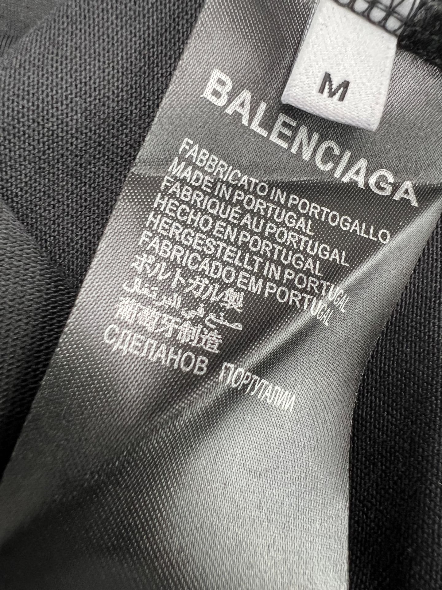 Balenciaga BALENCI*GA 城堡印花短袖 本品采用重磅精梳纯棉面料 经预缩与磨毛处理 触感柔软亲肤且挺括有型 宽松落肩版型适配多元穿搭场景 穿着无束缚感 正面印花采用多色胶印叠加植绒工艺 先以高饱和度油墨还原火焰字母与暗黑城堡轮廓 层次分明立体感强 再通过植绒工艺赋予图案细腻绒面质感 视觉与触觉双重丰富 领口采用双针罗纹包边 加固耐穿不易变形 肩线与侧缝采用高密平缝技术 车线工整平整 久洗不易开线脱线 版型数据经过精准调试 各尺码衣长 胸围 肩宽等参数匹配oversize潮流风格 兼顾舒适度与街头造型感 满足不同身形穿着需求 整体走线平直细腻 面料舒适柔软 颜色一致无色差 能与同款搭配营造 造型 驾驭各种场合 定制辅料 三标齐全