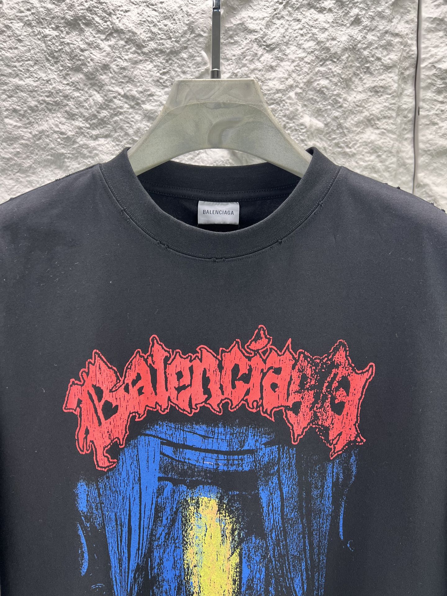 Balenciaga BALENCI*GA salon de couture艺术作品印花短袖本品采用重磅纯棉平纹面料 经预缩水处理后手感厚实挺括 亲肤透气且不易变形 适配日常高频穿着 印花部分采用直喷+胶印叠印工艺先以数码直喷精准还原蓝底黄晕的 做旧肌理 色彩层次丰富且晕染自然 再通过胶印叠加红色哥特字体轮廓 边缘做毛边破碎处理 强化暗黑摇滚视觉张力 同时保障印花牢固度 反复洗涤不易开裂脱落 车线采用双股高弹线 领口 袖口及下摆均做三本针加固 领口内置弹力罗纹并加定型条 有效避免洗后松垮变形 成衣经过酵素洗水做旧处理 整体呈现 做旧质感 风格硬核且穿着舒适 适配街头 摇滚等多元场景 整体走线平直细腻 面料舒适柔软 颜色一致无色差 能与同款搭配营造 造型 驾驭各种场合 定制辅料 三标齐全