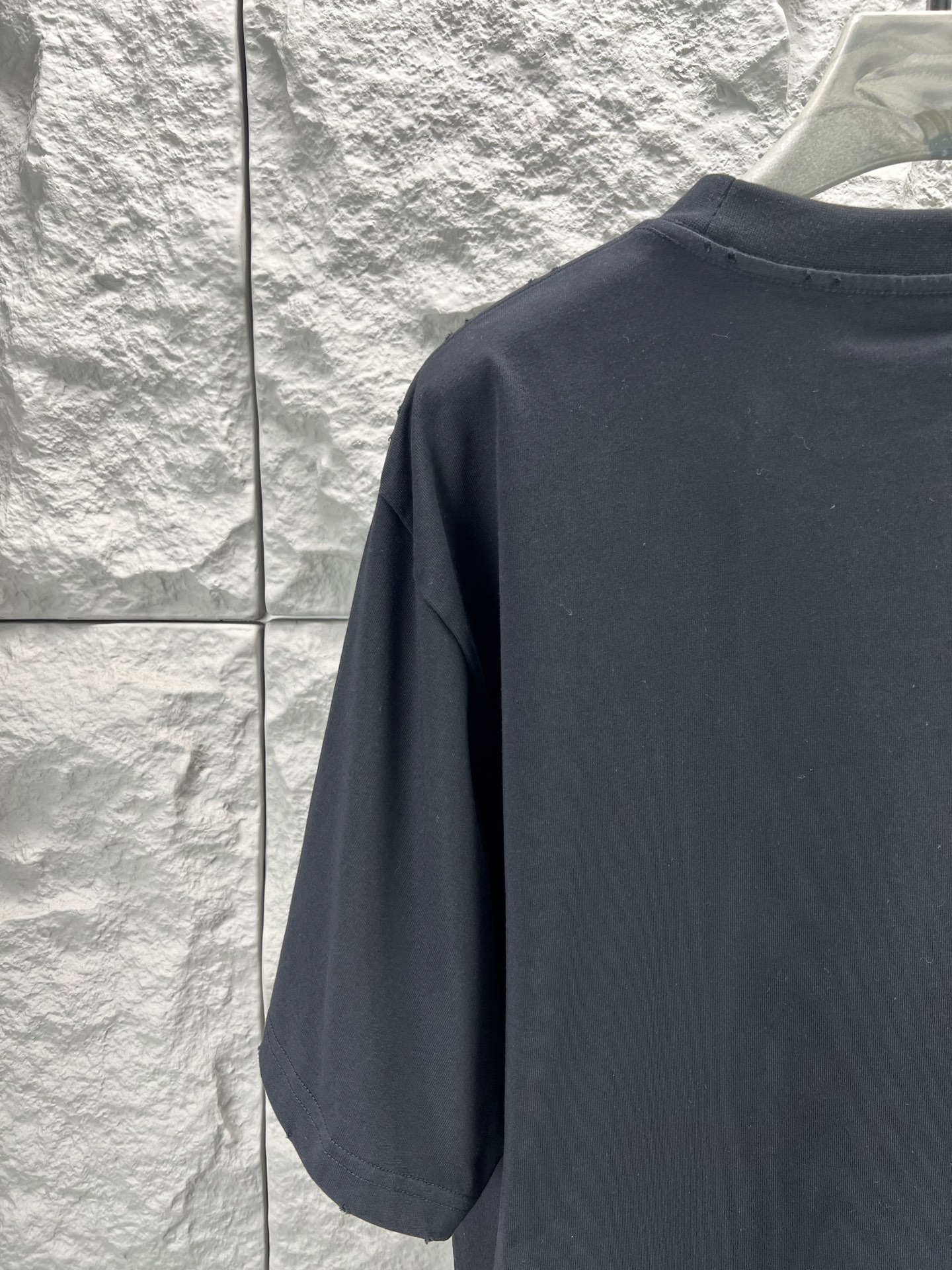 Balenciaga BALENCI*GA salon de couture艺术作品印花短袖本品采用重磅纯棉平纹面料 经预缩水处理后手感厚实挺括 亲肤透气且不易变形 适配日常高频穿着 印花部分采用直喷+胶印叠印工艺先以数码直喷精准还原蓝底黄晕的 做旧肌理 色彩层次丰富且晕染自然 再通过胶印叠加红色哥特字体轮廓 边缘做毛边破碎处理 强化暗黑摇滚视觉张力 同时保障印花牢固度 反复洗涤不易开裂脱落 车线采用双股高弹线 领口 袖口及下摆均做三本针加固 领口内置弹力罗纹并加定型条 有效避免洗后松垮变形 成衣经过酵素洗水做旧处理 整体呈现 做旧质感 风格硬核且穿着舒适 适配街头 摇滚等多元场景 整体走线平直细腻 面料舒适柔软 颜色一致无色差 能与同款搭配营造 造型 驾驭各种场合 定制辅料 三标齐全