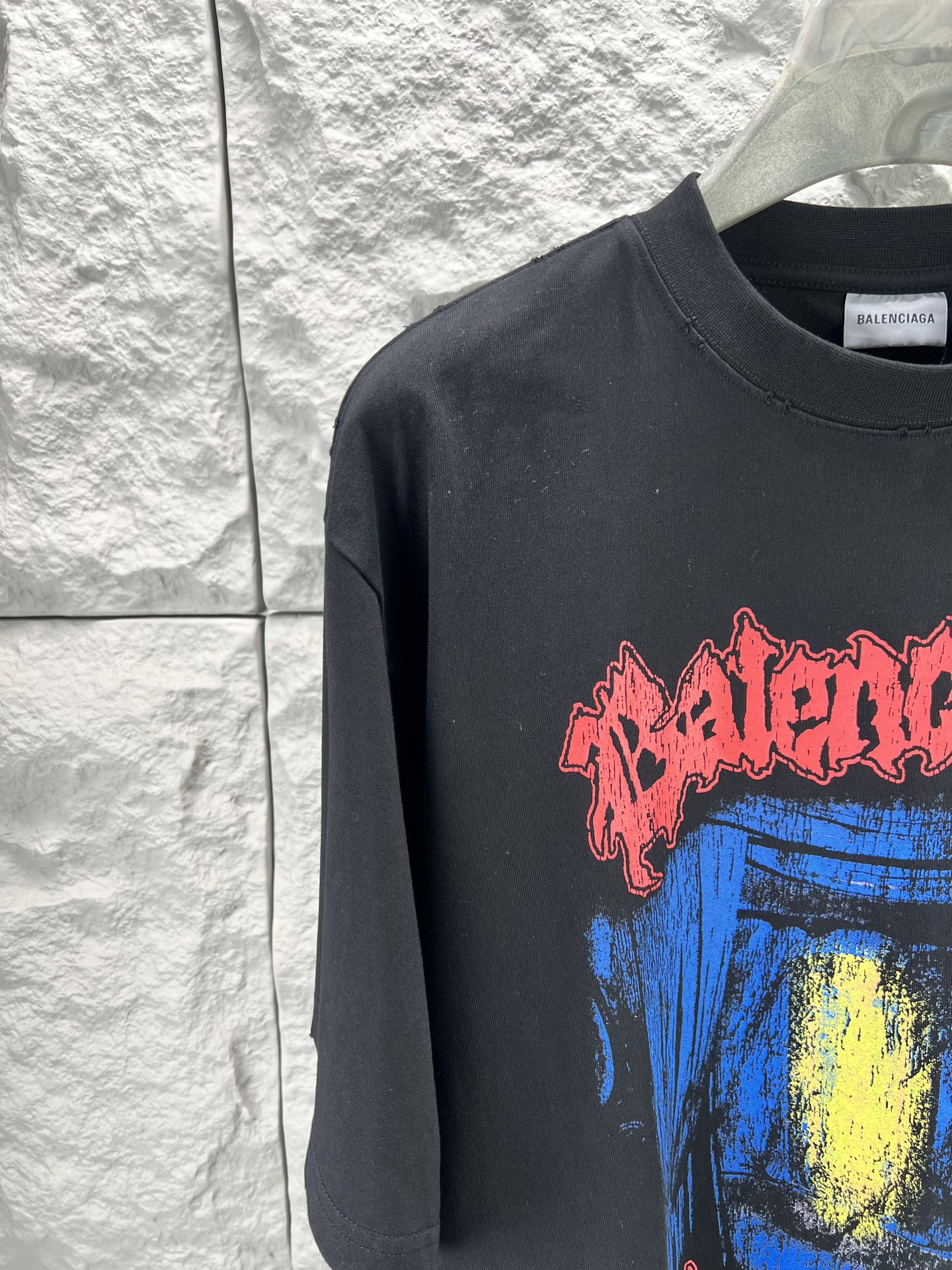 Balenciaga BALENCI*GA salon de couture艺术作品印花短袖本品采用重磅纯棉平纹面料 经预缩水处理后手感厚实挺括 亲肤透气且不易变形 适配日常高频穿着 印花部分采用直喷+胶印叠印工艺先以数码直喷精准还原蓝底黄晕的 做旧肌理 色彩层次丰富且晕染自然 再通过胶印叠加红色哥特字体轮廓 边缘做毛边破碎处理 强化暗黑摇滚视觉张力 同时保障印花牢固度 反复洗涤不易开裂脱落 车线采用双股高弹线 领口 袖口及下摆均做三本针加固 领口内置弹力罗纹并加定型条 有效避免洗后松垮变形 成衣经过酵素洗水做旧处理 整体呈现 做旧质感 风格硬核且穿着舒适 适配街头 摇滚等多元场景 整体走线平直细腻 面料舒适柔软 颜色一致无色差 能与同款搭配营造 造型 驾驭各种场合 定制辅料 三标齐全
