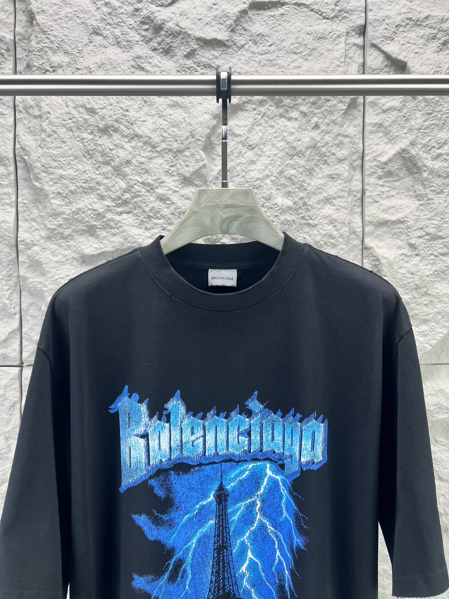 Balenciaga BALENCI*GA 铁塔闪电印花T恤 本品采用重磅精梳纯棉面料经预缩水处理 触感厚实挺括 宽松落肩版型贴合街头潮流风格 兼顾舒适与造型感 正面印花采用胶印结合做旧磨边工艺 先以高饱和度油墨还原蓝色闪电与埃菲尔铁塔轮廓