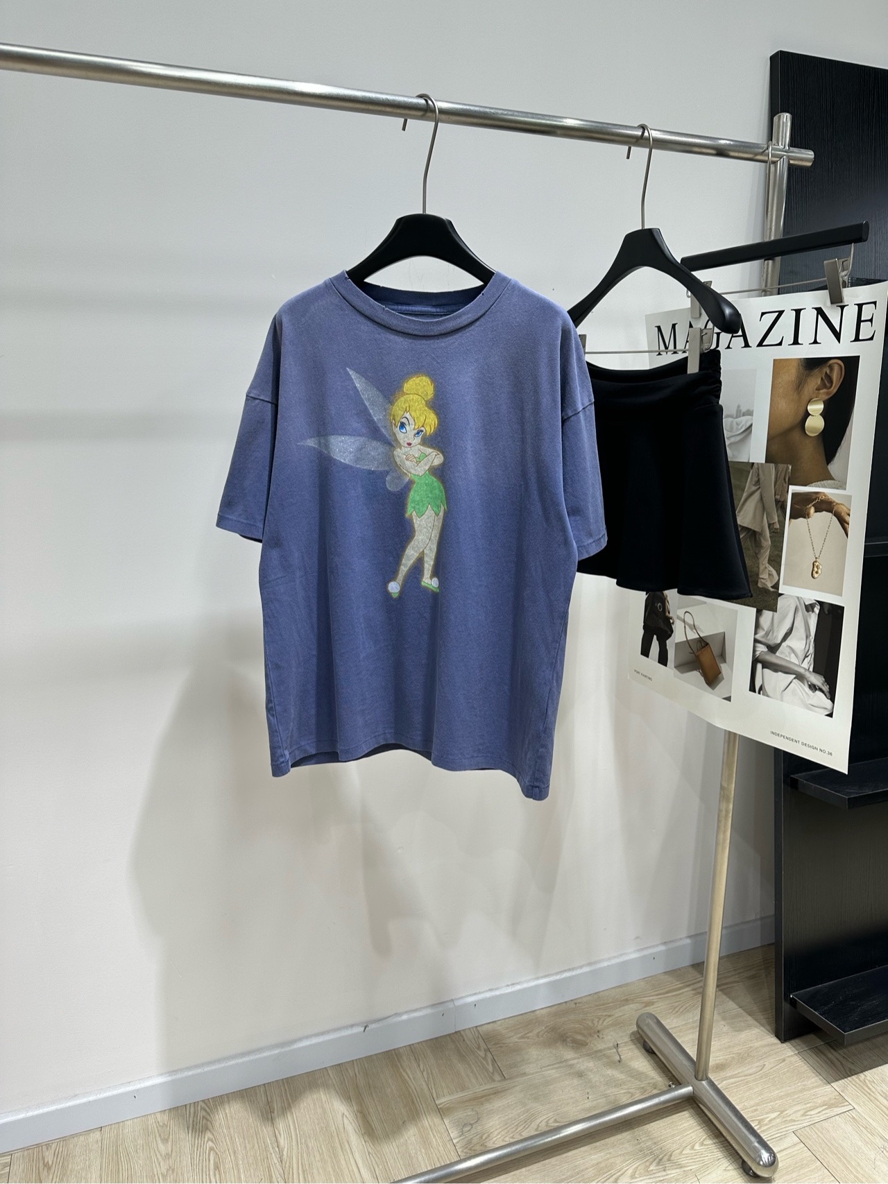 NO:823442,[Sa Haze Smurfs printed short-sleeved T-shirt], fabric cotton, color haze blue, 26SS Disney co-branded Wonderful Fairy Tinker Bell elf print, letter luminous round neck short-sleeved T-shirt, same style as Chen He, Ma Sichun, porsuppakarn, Saint style Disney Wonderful Fairy co-branded T-shirt, wear starlight on your body, when retro and old street genes collide with Disney's fairy magic. This washed gray short-sleeved piece is the 'starlight carrier' hidden in the closet.  The washed distressing process gives the cotton fabric a matte distressed texture. The high-weight fabric is crisp and not soft. The dropped shoulder sleeves are cut to take up the looseness. The round neck is double-layered with ribbing, which is not easy to deform after long-term wear♀. The tinkerbell print on the front uses glitter + luminous technology. The wings will emit a fine silver glow in the dark. The letters 'Saint' on the back are surrounded by stars, like Peter Pan's Never Island sewn onto the hem.  The washed haze blue comes with a microdermabrasion filter. It can be worn casually with cargo shorts or wide-leg jeans. It has a street atmosphere with a sense of story♀ There is no unnecessary decoration, only relying on the old texture and joint IP to speak. It combines the retro street and childish romance into a relaxed feeling that can be worn daily. Flat size S Shoulder width 58, bust 112, length 65, sleeve length 20 M Shoulder width 59, chest 116, length 67, sleeve length 21  L shoulder width 60, chest 120, length 69, sleeve length 22. Manual measurement will have an error of 2 to 3cm, which is within the normal range, saint laurent, shorts, jeans, T-shirt, tees, t-shirt,19860909【Sa雾霾蓝小精灵印花短袖T】 ,面料棉 颜色雾霾蓝 26SS迪士尼联名奇妙仙子小叮当精灵印花 字母夜光圆领短袖T恤 陈赫、马思纯、porsuppakarn同款 Saint风迪士尼奇妙仙子联名T恤 把星光穿在身上 当复古做旧的街头基因撞上迪士尼的精灵魔法 这件水洗灰短袖就是藏在衣橱里的「星光载体」 水洗做旧工艺让棉织物自带雾面做旧肌理 高克重面料挺括不软塌 落肩袖剪裁把松弛感拉满 圆领做了双层罗纹包边 久穿也不易变形♀ 正面小叮当印花用了闪粉+夜光工艺 翅膀在暗处会泛出细碎银辉 背后“Saint”字母被星芒环绕 像把彼得潘的永无岛缝在了衣摆 水洗雾霾蓝自带磨皮滤镜 随便搭工装短裤或阔腿牛仔裤 就是自带故事感的街头氛围感♀ 没有多余装饰,只靠做旧质感和联名IP说话 把复古街头和童趣浪漫揉成了日常可穿的松弛感 平铺尺码 S肩宽58,胸围112,衣长65,袖长20 M肩宽59,胸围116,衣长67,袖长21 L肩宽60,胸围120,衣长69,袖长22 手工测量会有2～3cm误差属于正常范围,,saint laurent,shorts,jeans,T-shirt,tees，t-shirt,,Women's clothing