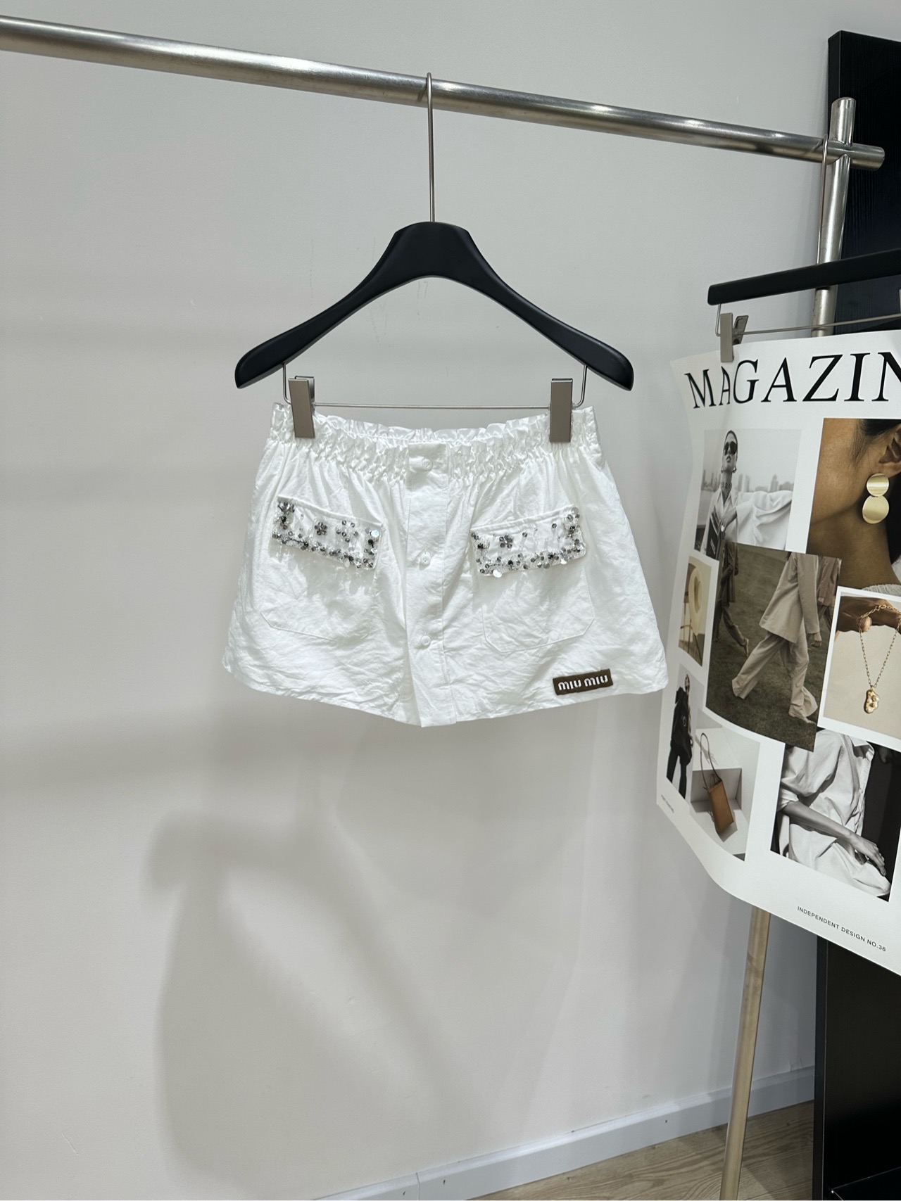 NO:945100,[M White Beaded Double Pocket Casual Skirt], fabric cotton, color white, Miu* white beaded elastic waist skirt. The fabric is made of light and breathable cotton fabric. It has a soft washed texture, which makes the upper body dry and not stuffy. It is very comfortable to wear in summer. The fabric is flexible and durable, not easy to deform after daily washing. Pure white, clean and refreshing, suitable for all kinds of tops. The waist is made of elastic wrap design, which is very tolerant to the waist and can be put on and taken off easily. Front button placket  The edges of the pockets on both sides are decorated with exquisite beading and small flower embroidery. The brand leather label is sewn on the lower right side, and the details are full of girlish sophistication. The loose A-line pants can modify the crotch and thigh lines. They visually make the legs slimmer and longer. There are many wearing scenarios. It can be worn with simple T-shirts and knitted short sleeves for daily outings. It can also be worn with shirts and small cardigans for light commuting. It is refreshing and versatile. Flat size S waist 66 elastic, hip 106, skirt length 31  M waist circumference 70 elasticity, hip circumference 110, skirt length 32 L waist circumference 74 elasticity, hip circumference 114, skirt length 33. Manual measurement will have an error of 2~3cm, which is within the normal range, miumiu, skirts, shirts, T-shirt, tees, t-shirt,19860909【M白色钉钻双口袋花苞休闲半裙】 ,面料棉 颜色白色 Miu*白色钉珠松紧腰半裙 面料选用轻薄透气的棉感面料 自带柔和的水洗肌理,上身干爽不闷 夏日穿着舒适度很高 面料柔韧耐穿,日常洗涤不易变形 纯白色干净清爽,适配各类上衣 腰头做弹力打揽设计 对腰围包容度强,穿脱自在 正面纽扣开襟 两侧口袋边缘点缀精致钉珠、小花刺绣 右下侧缝制品牌皮标,细节充满少女精致感 宽松A字裤型可以修饰胯部、大腿线条 视觉上显瘦显腿长 穿搭场景丰富 搭配简约T恤、针织短袖可日常出游逛街 搭配衬衫、小开衫也能适配轻通勤穿搭,清爽百搭 平铺尺码 S腰围66弹力,臀围106,裙长31 M腰围70弹力,臀围110,裙长32 L腰围74弹力,臀围114,裙长33 手工测量会有2~3cm误差属于正常范围,,miumiu,skirts,shirts,T-shirt,tees，t-shirt,,Women's clothing