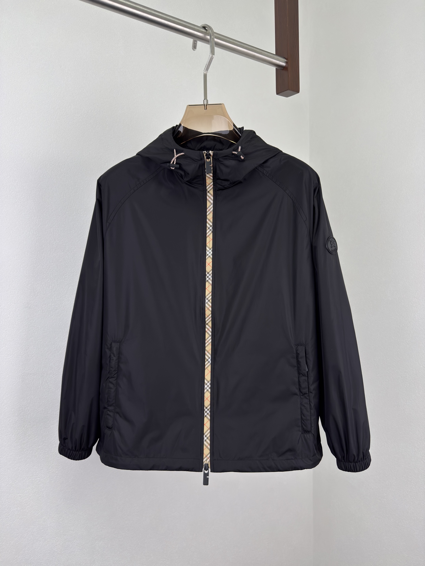 NO:515230,Burberry 25 Autumn and Winter plaid nylon thin cotton hooded jacket. Classic reshaping, agile and windproof. Classic rebirth, plaid contemporary narrative, iconic Burberry plaid wanders around the body in the form of a tape, like a flowing British poem, injecting the elegant genes accumulated by the brand for a century into a modern context. The B-shaped cut zipper head echoes the plaid stitching, and craftsmanship is also seen in the tiny areas. Classic symbols are reborn in innovative craftsmanship. Light nylon fabric, loose silhouette is free and unrestrained. The visual badge of the chivalrous spirit, the equestrian knight pattern on the silicone patch on the chest, originated from the legendary Burberry design of the 1980s. This exquisite decal is not only an index of the brand's history, but also condenses the chivalrous spirit of fearless exploration into visual symbols.  Functional aesthetics, free-waving urban armor, two-way zipper opening and closing smoothly, unlocking different wearing postures. Contrasting color drawstring hood and hem are adjusted with the wind, and windproof is also shaped, adapting to multiple scene needs. The side zipper pockets are hidden and stored to protect the security of personal belongings. The elastic cuffs fit the wrists, neat and not bloated, and make them more free and easy in action. Light nylon fabrics are windproof and waterproof, without fear of changing weather, freely traveling through the city and nature. Ragnarok sleeves, inclusive and diverse postures, and are more relaxed than the regular version, breaking the constraints and giving the body a space for stretching. It does not define your posture, but only fulfills your freedom. Color black Military green Size M-3XL (48-56),,burberry,jackets & coats,hats,alexander wang19860909Burberry25秋冬 格纹饰边尼龙薄棉连帽外套.经典重塑,灵动防风. 经典重生,格纹的当代叙事,标志性 Burberry 格纹以贴带形式游走于衣身,如流动的英伦诗行,将品牌百年积淀的优雅基因注入现代语境.B 型剪裁拉链头与格纹缝线默契呼应,微小之处亦见匠心,经典符号在创新工艺中焕发新生.轻盈尼龙面料,宽松廓形自在不拘束. 骑士精神的视觉徽章,胸前硅胶贴片上的马术骑士图案,源自 1980 年代 Burberry 传奇设计.这枚精致贴花不仅是品牌历史的索引,更将无畏探索的骑士精神凝为视觉符号. 功能美学,自由穿梭的都市铠甲,双向拉链开合流畅启闭,解锁不同穿着姿态.撞色抽绳兜帽与下摆随风调节,防风亦塑形,适配多场景需求.侧边拉链口袋隐蔽收纳,守护随身物品的安全感.弹性袖口贴合手腕,利落不臃肿,行动间更显洒脱.轻盈尼龙面料防风防水,无惧天气变幻,自由穿行城市与自然.插肩袖型,包容多元姿态,比常规版型更松弛的剪裁,打破束缚,赋予身体舒展空间.它不定义你的姿态,只成全你的自在. 颜色黑色 军绿色 尺码M-3XL (48-56),,burberry,jackets & coats,hats,alexander wang,Men's clothing