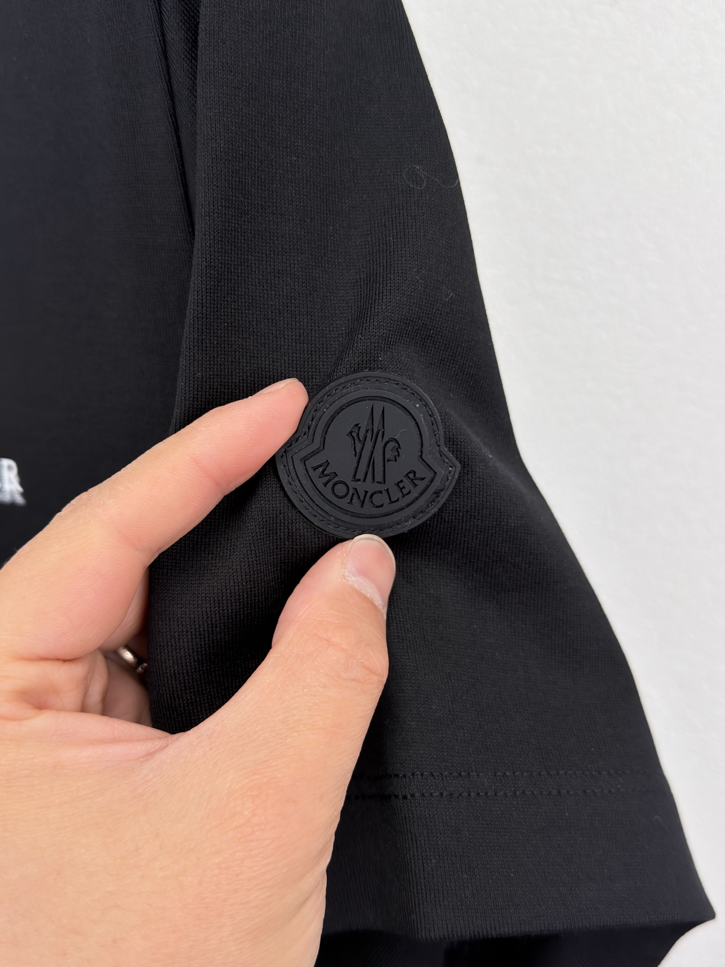 MONCLER 26春夏 黑标系列，这款T恤是品牌DNA的现代创新宣言——将经典的户外黑标系列标志大胆重