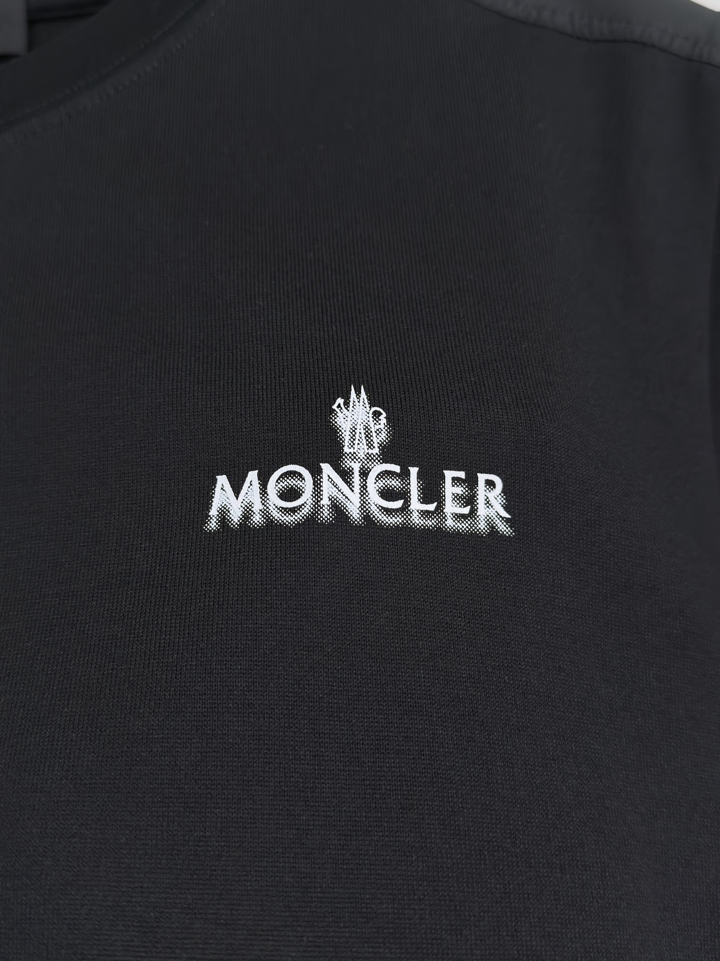 MONCLER 26春夏 黑标系列，这款T恤是品牌DNA的现代创新宣言——将经典的户外黑标系列标志大胆重