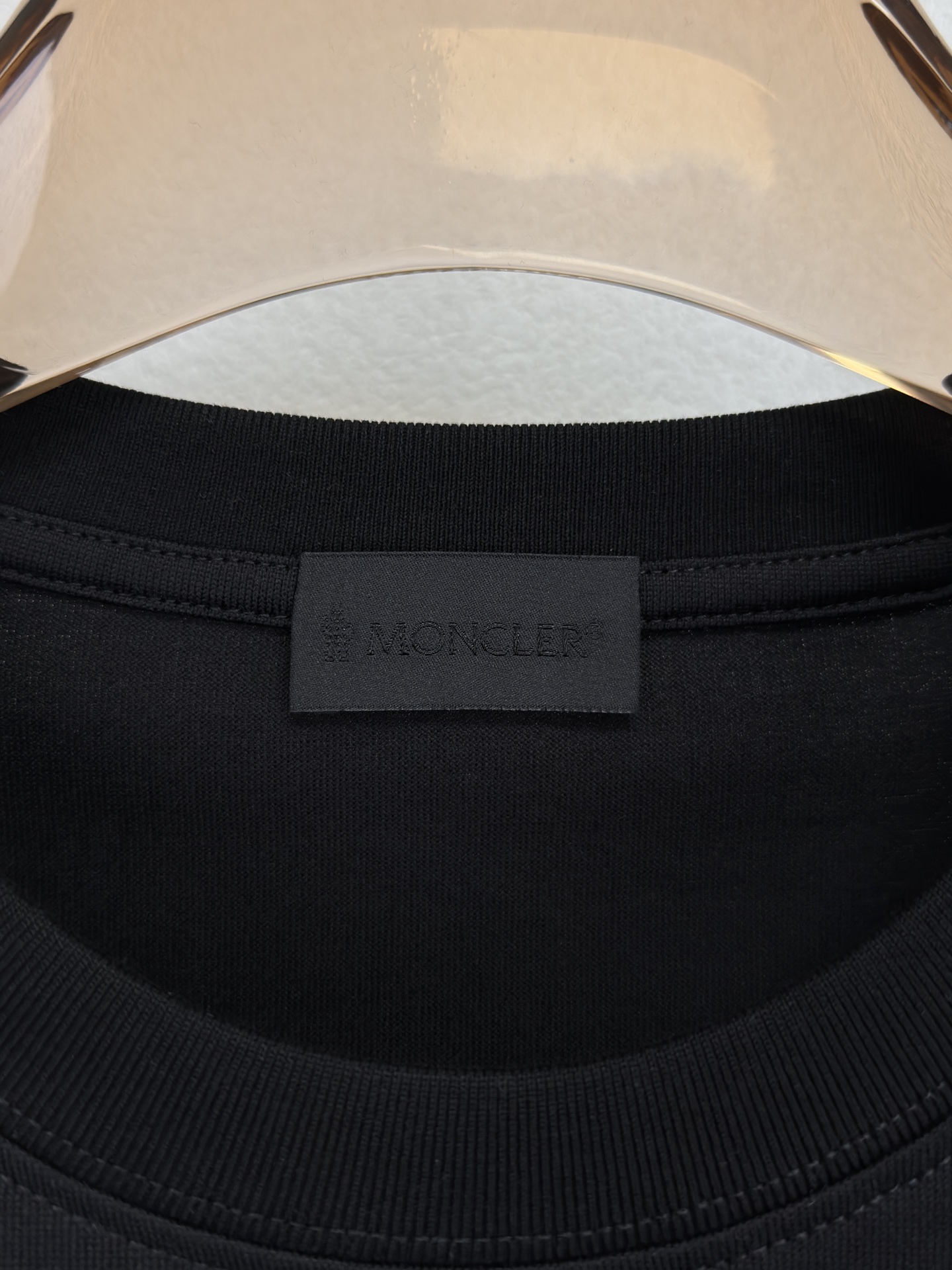 MONCLER 26春夏 黑标系列，这款T恤是品牌DNA的现代创新宣言——将经典的户外黑标系列标志大胆重